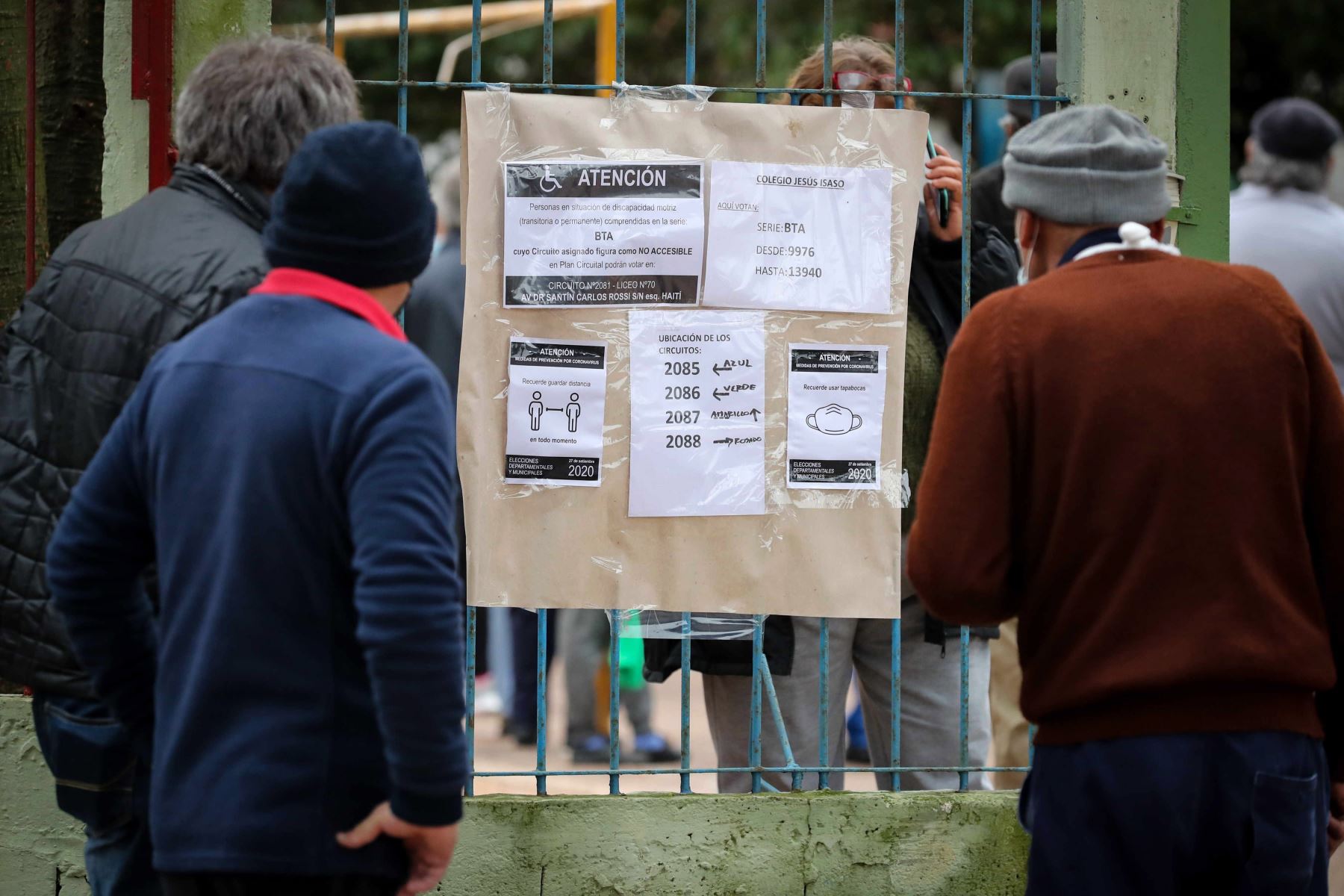 Personas observan listas de centros electorales durante el desarrollo de las elecciones departamentales, en Montevideo. 
Foto: EFE