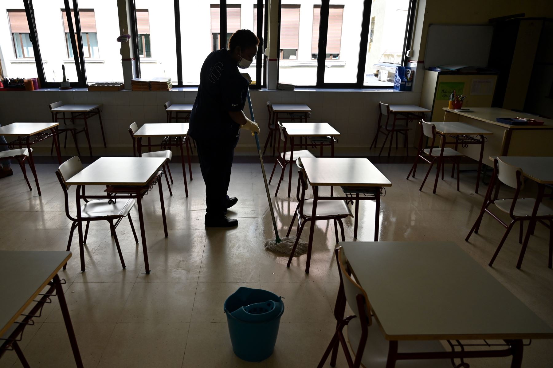 Un miembro del personal de limpieza desinfecta las aulas de un centro de estudios en Madrid. Escuelas han cerrado debido al rebrote del coronavirus. Foto: AFP