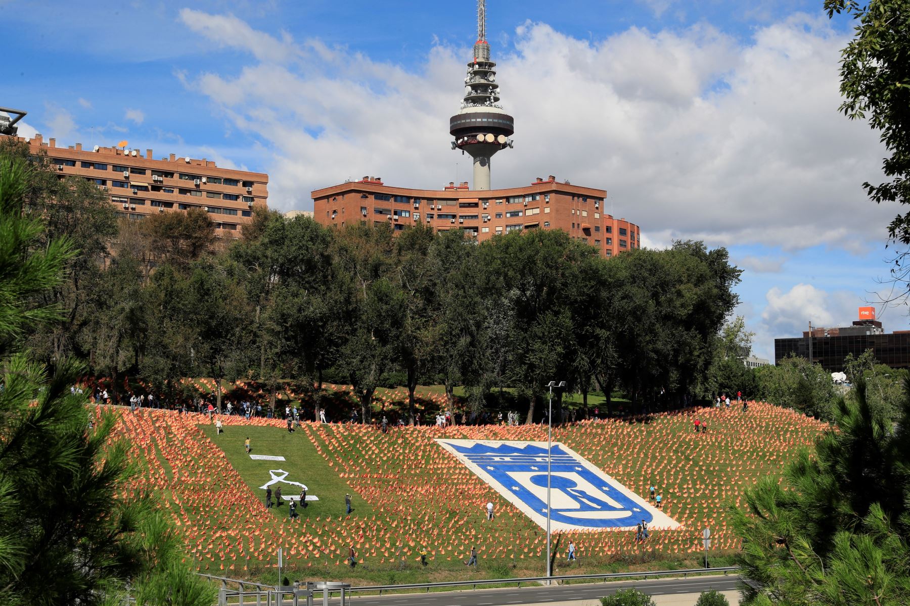 Personas transitan entre miles de banderas españolas, que representan a las víctimas  Covid-19, en el parque de Roma, en Madrid. Foto: EFE