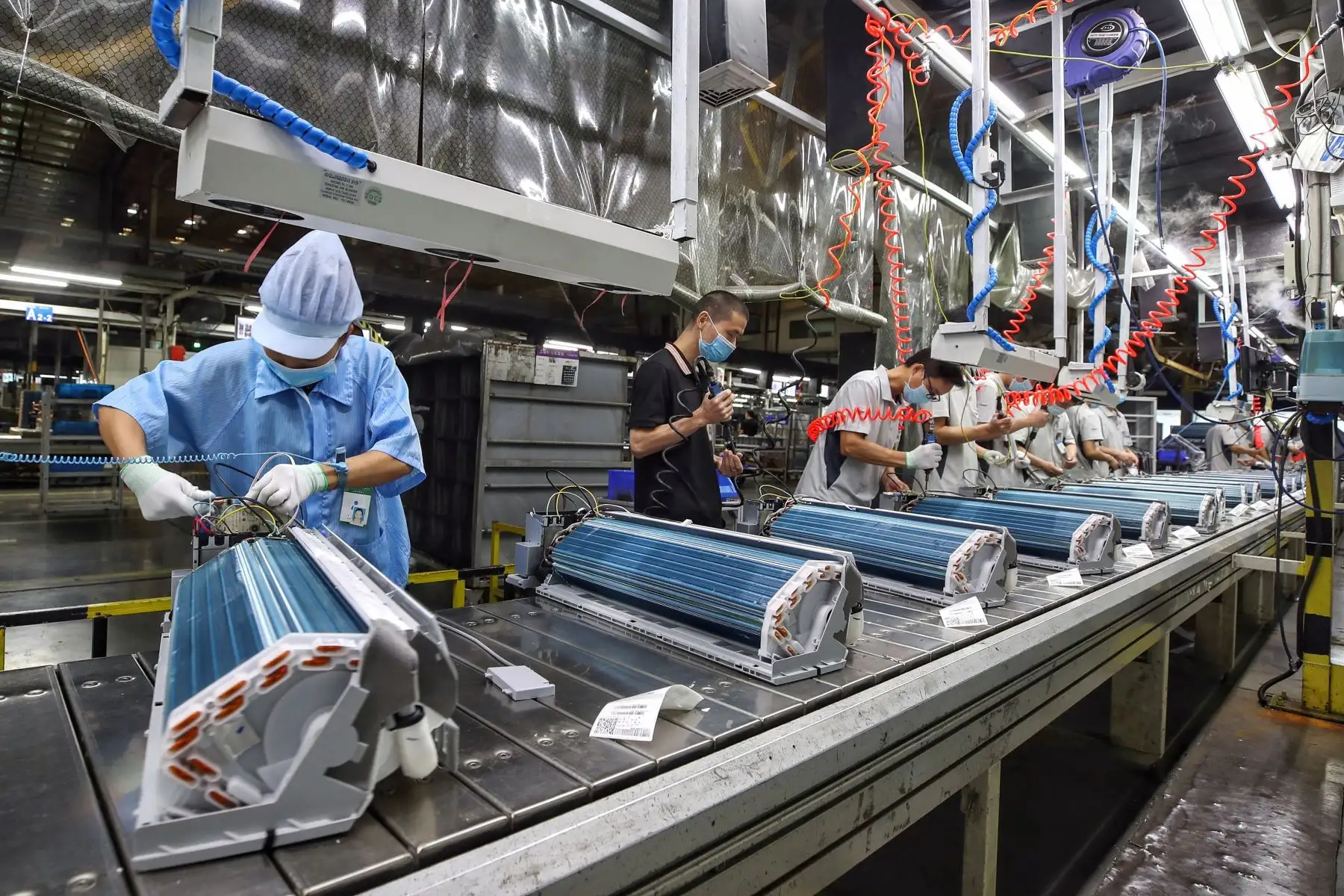 Los empleados trabajan en una línea de producción de aire acondicionado en una fábrica de Haier en Wuhan, en la provincia central de Hubei, China. Foto: AFP