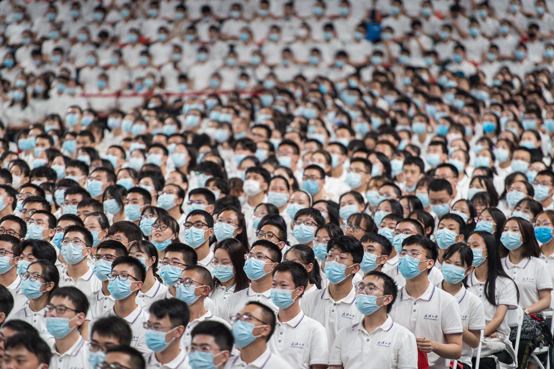 Esta foto tomada el 26 de septiembre de 2020 muestra a estudiantes de primer año con máscaras como medida preventiva contra el coronavirus durante una ceremonia de graduación en la Universidad de Wuhan. Foto: AFP