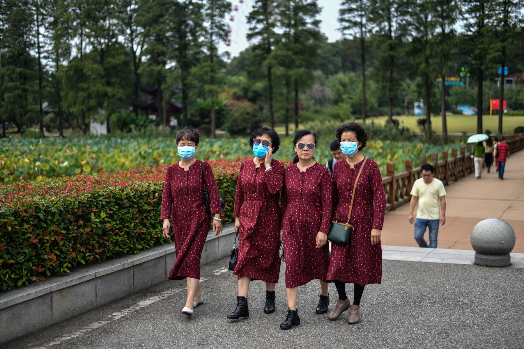 Mujeres que usan mascarillas como medida preventiva contra el coronavirus visitan el área escénica de Moshan cerca del lago East en Wuhan, en la provincia central de Hubei de China. Foto: AFP