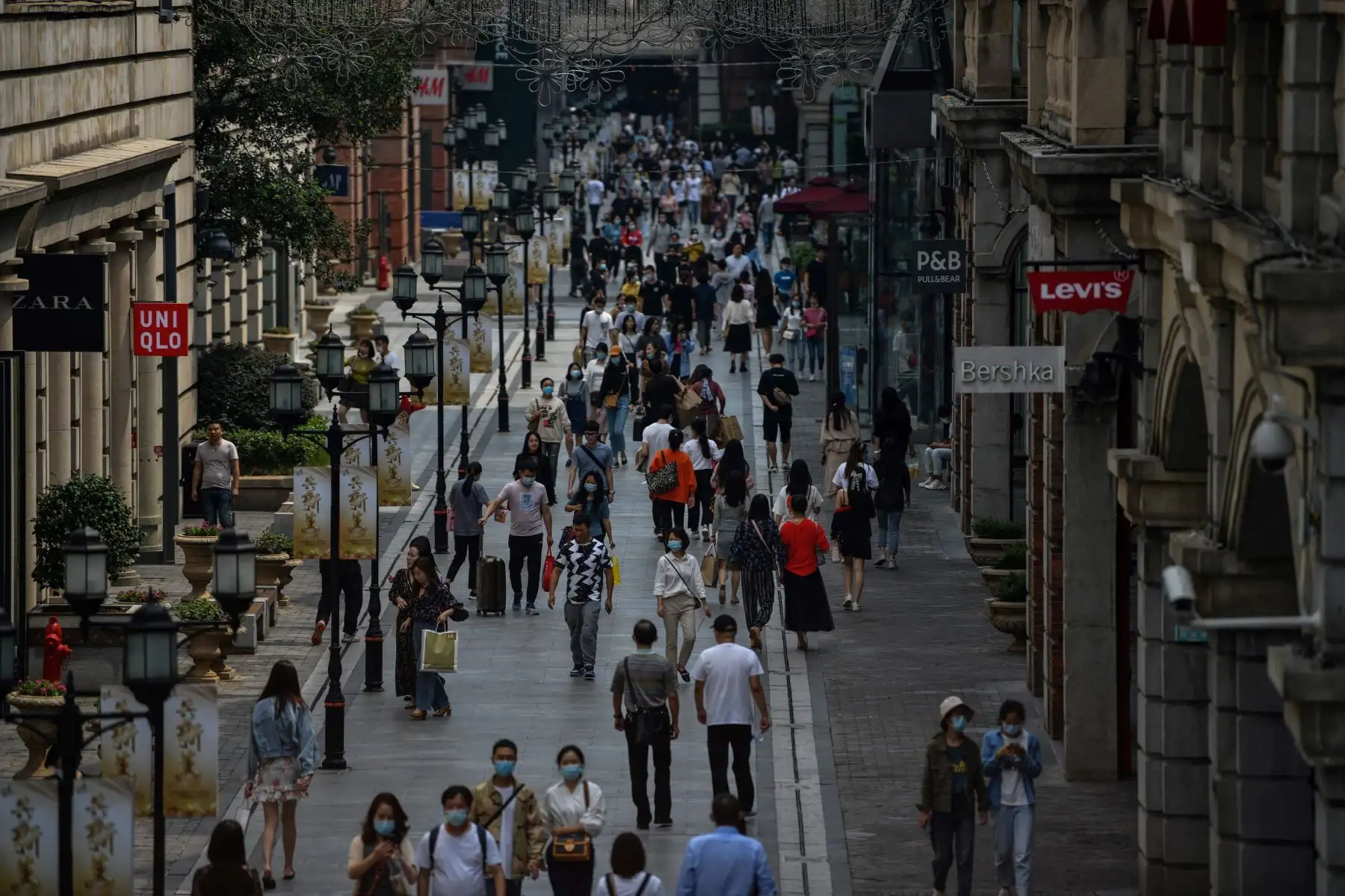 Personas que usan mascarillas como medida preventiva contra el coronavirus COVID-19 caminan en una calle peatonal en Wuhan, en la provincia central de Hubei, China. Foto: AFP