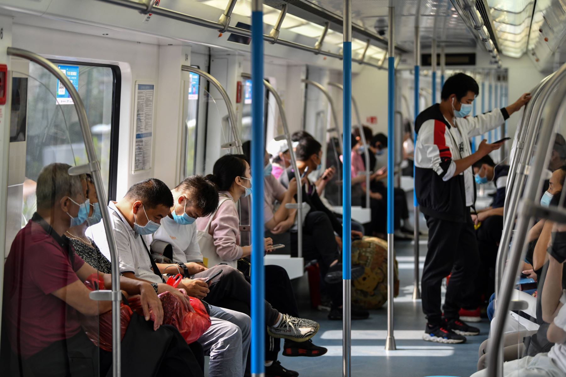 Los pasajeros, con máscaras faciales en medio de las precauciones contra el coronavirus, viajan en el metro en Wuhan, en la provincia central de Hubei, en China. Foto: AFP