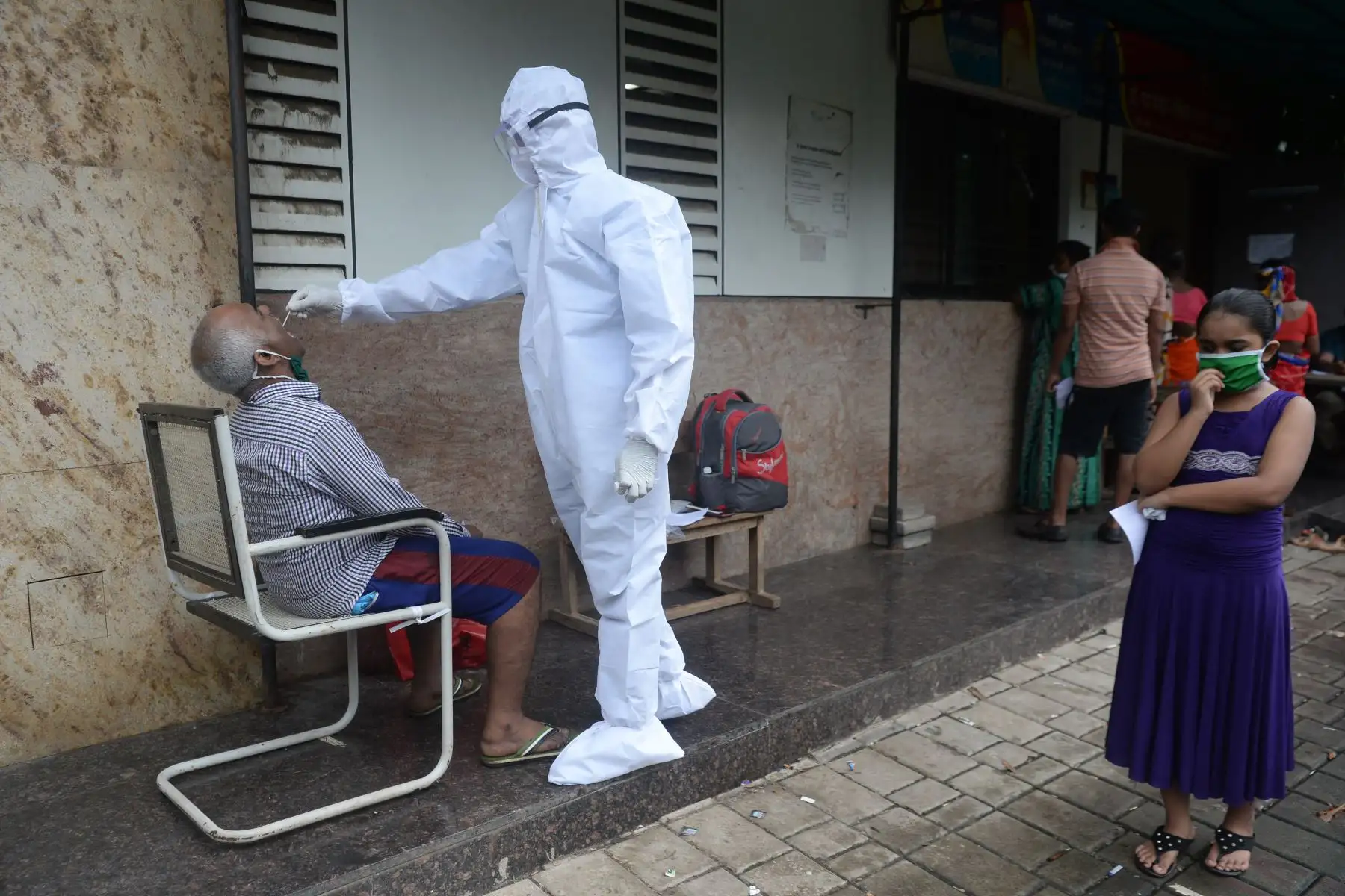 Un trabajador de la salud toma un hisopado de garganta durante una prueba de detección del coronavirus, en Mumbai. Foto: AFP
