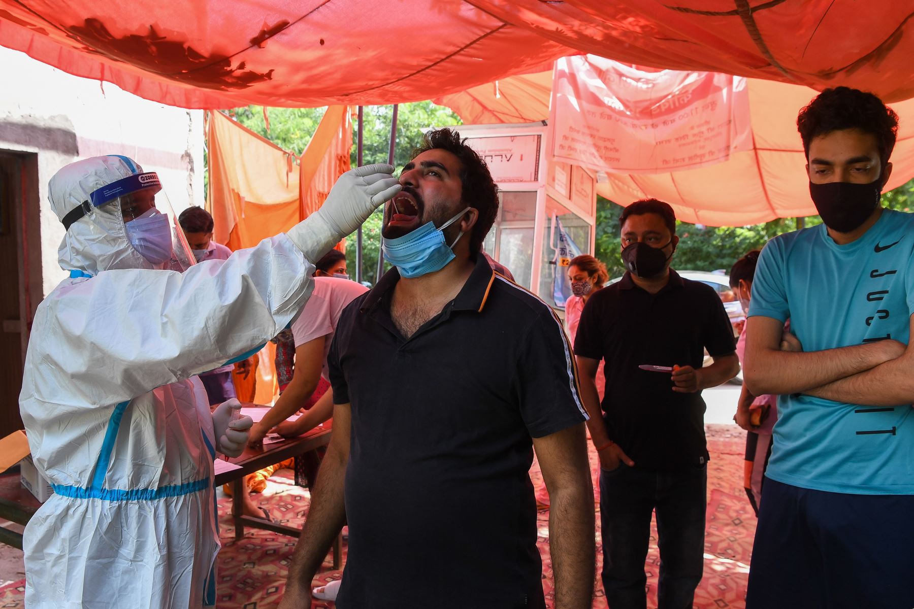 Un trabajador médico toma una muestra de hisopo de un hombre, en Ghaziabad. Foto: AFP