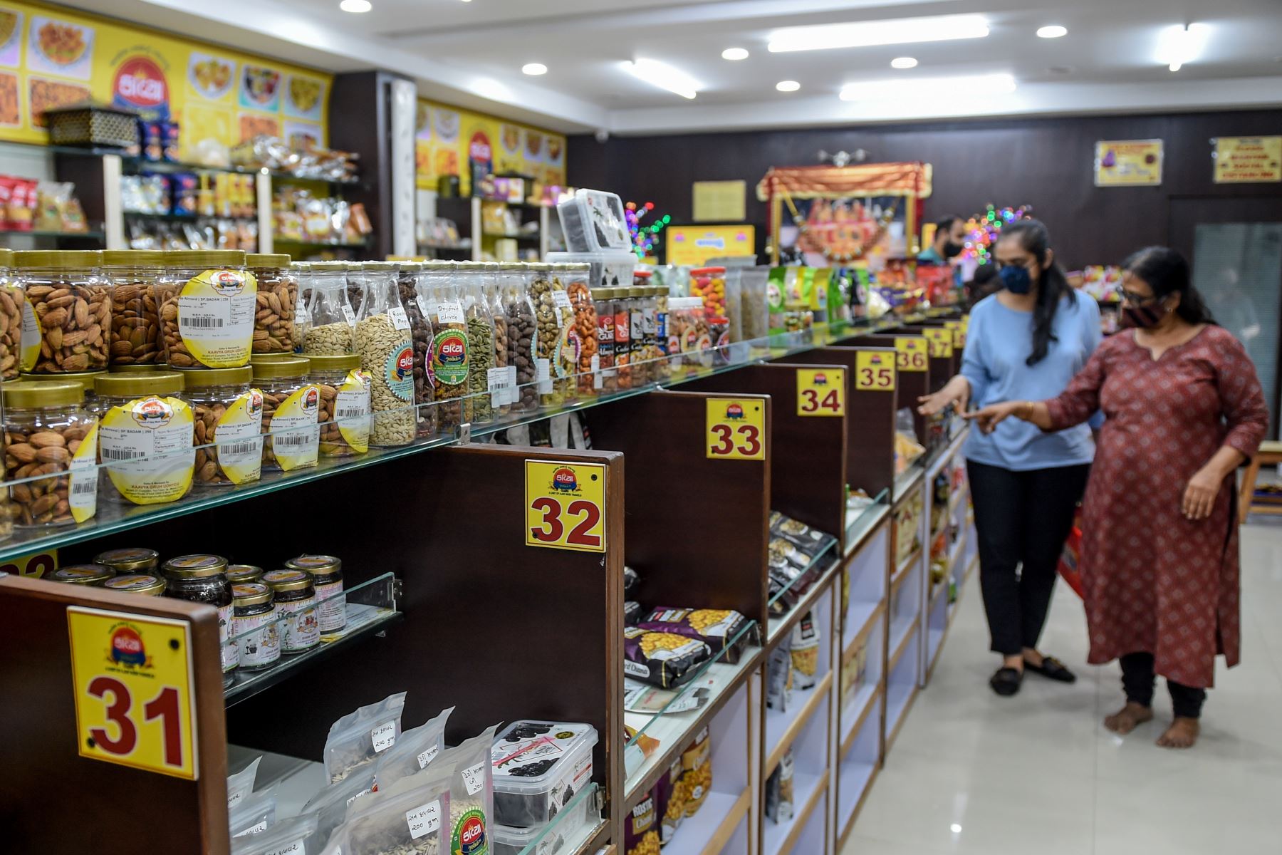 Los clientes observan los estantes de alimentos en una tienda de Ahmedabad, en India. Foto: AFP
