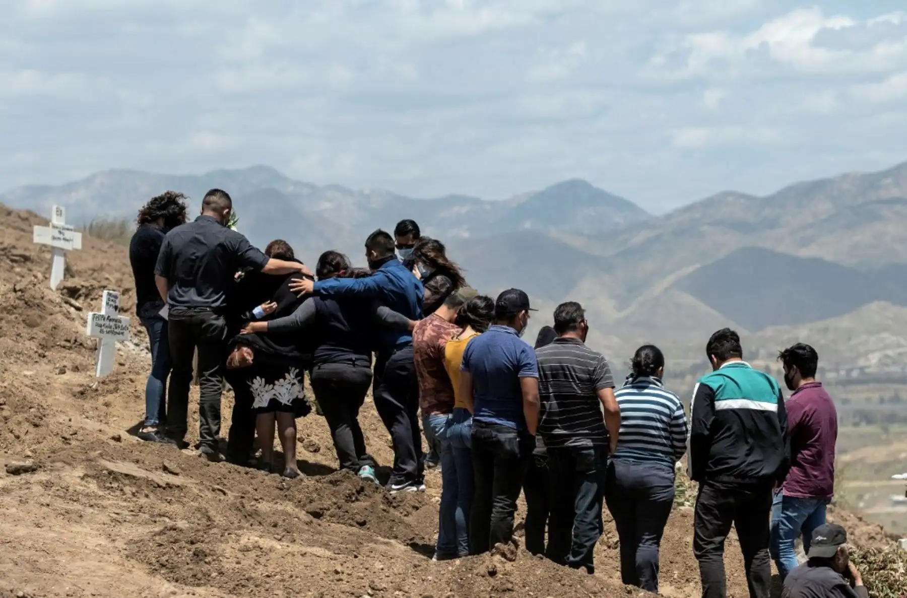 Familiares de fallecidos por Covid-19 se paran junto a las tumbas en el Cementerio Municipal número 13 en Tijuana, Estado de Baja California, México. Foto:AFP