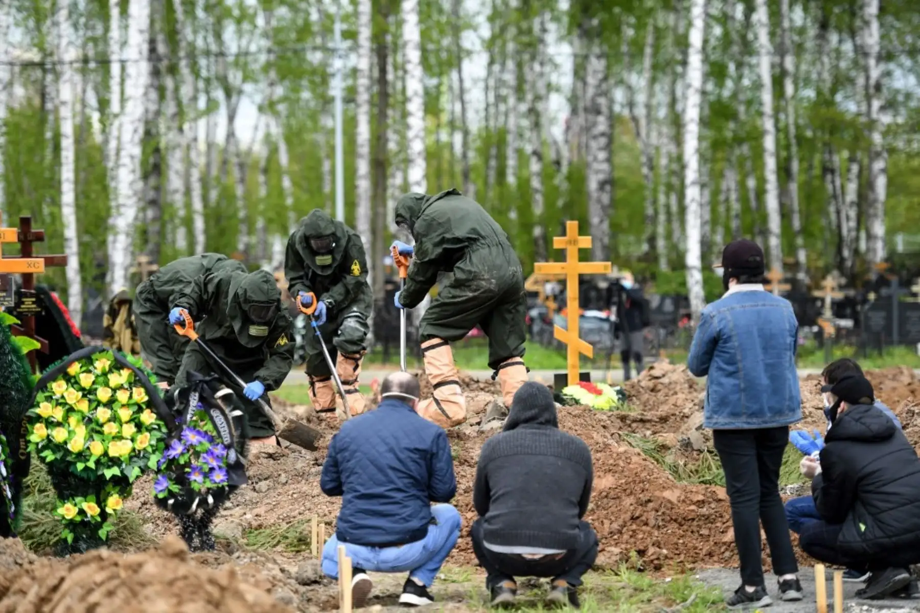 Trabajadores cubiertos con equipo de protección entierran a una víctima del coronavirus en un cementerio en de Moscú. Más de un millón de personas han muerto a causa del coronavirus. Foto: AFP