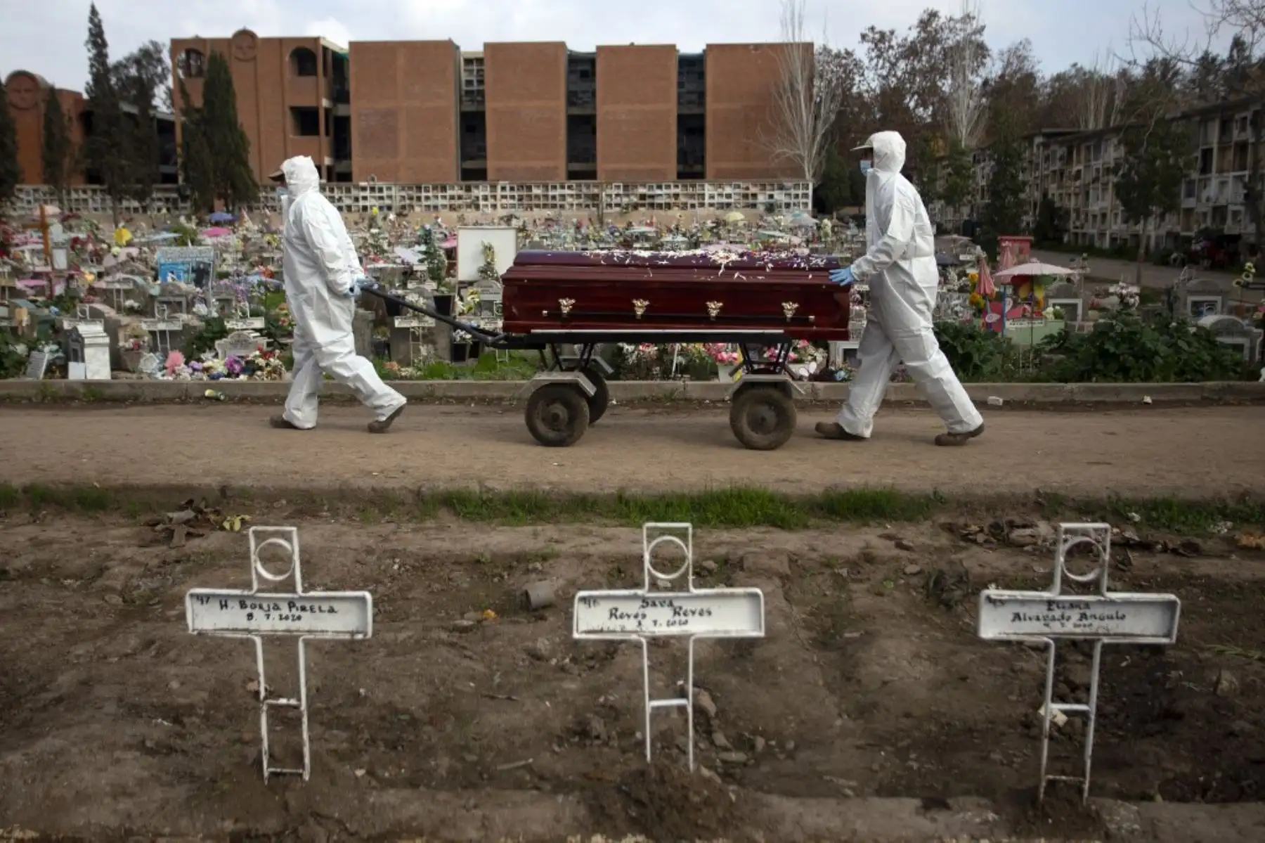 El sepulturero Fernando Quezada, de 27 años, y un compañero de trabajo, llevan un ataúd en el Cementerio General de Santiago de Chile, en medio de la pandemia del nuevo coronavirus. Foto: AFP