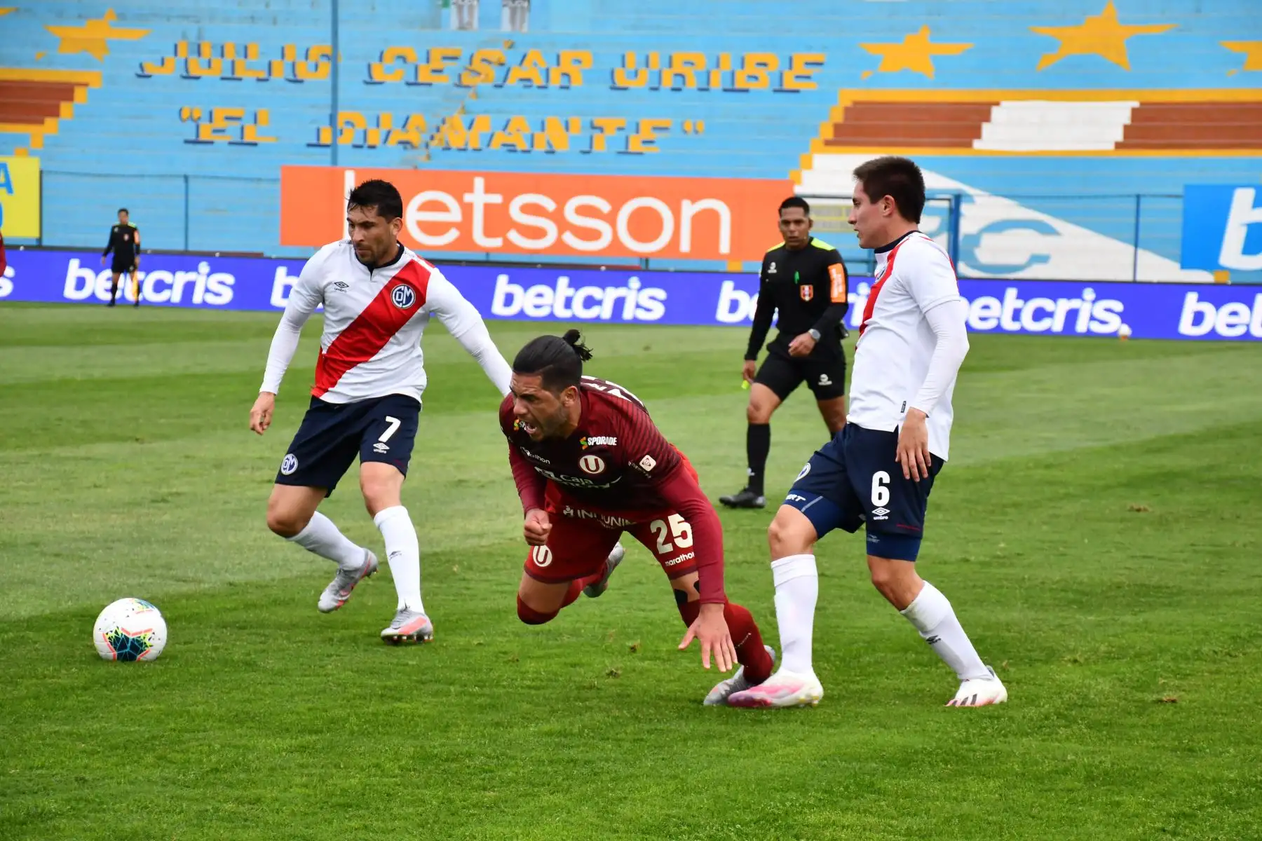 Jonathan Dos Santos de Universitario disputa el balón con Mario Velarde y Eduardo Pita de Municipal en el encuentro que culminó 5 a 0 a favor del cuadro crema por la fecha 15 del Torneo Apertura de la Liga 1. 

Foto: FPF