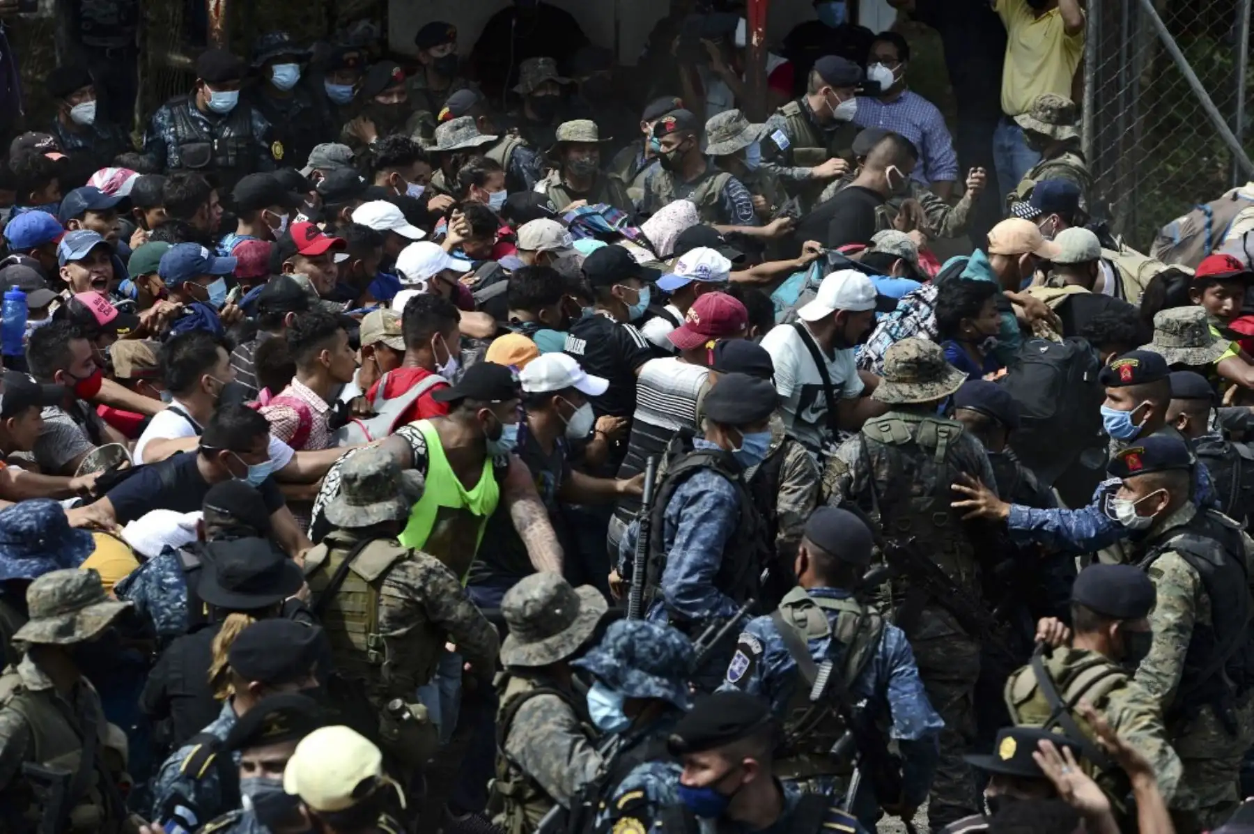 Migrantes hondureños rompen la valla policial para ingresar a Guatemala en su camino a los Estados Unidos, en la frontera de Corinto, Honduras, el 1 de octubre de 2020. La caravana salió de San Pedro Sula el miércoles a la medianoche en búsqueda del sueño americano. Foto: AFP