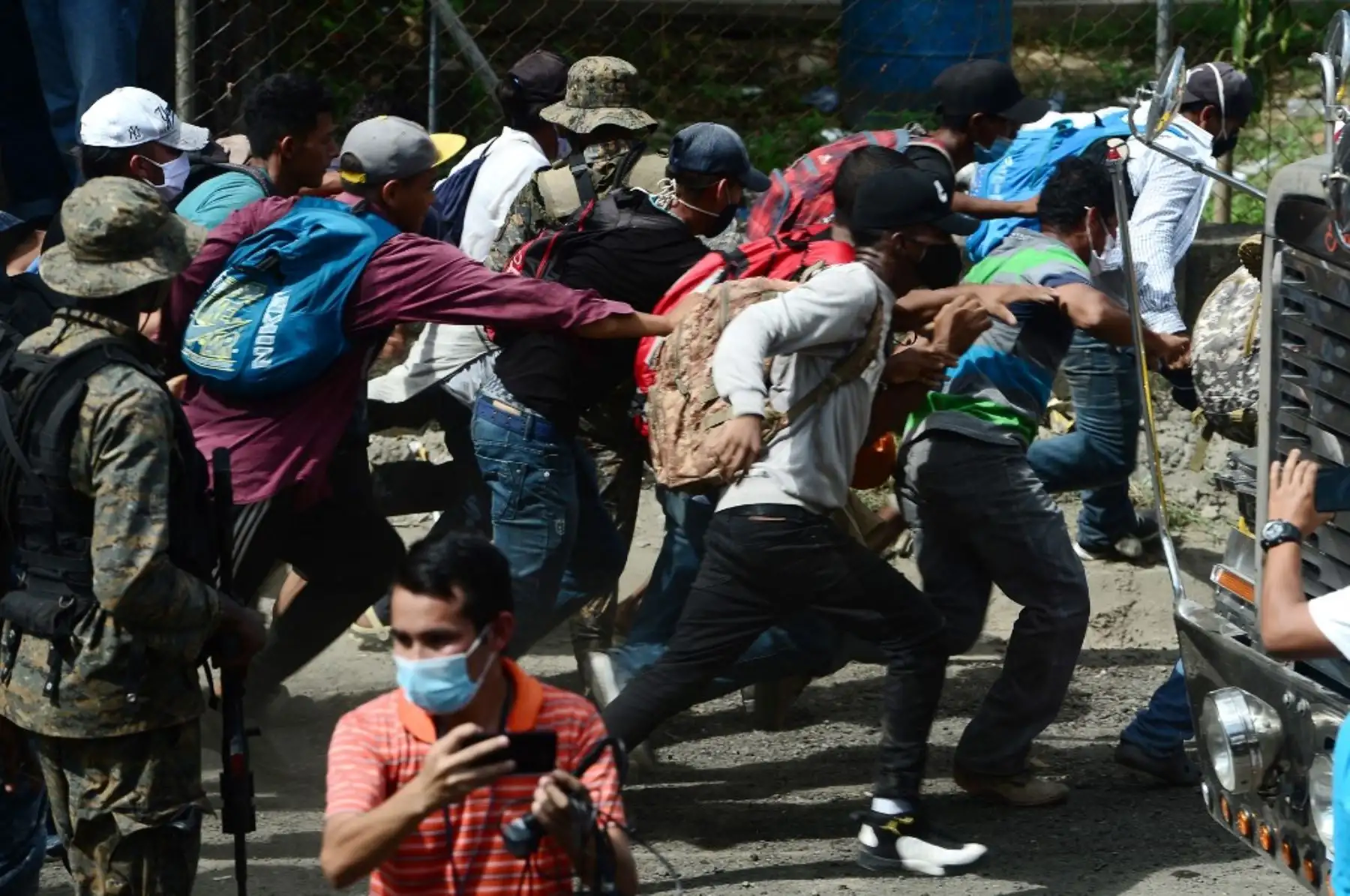 Migrantes hondureños rompen la valla policial para ingresar a Guatemala en su camino a los Estados Unidos, en la frontera de Corinto, Honduras. Foto: AFP