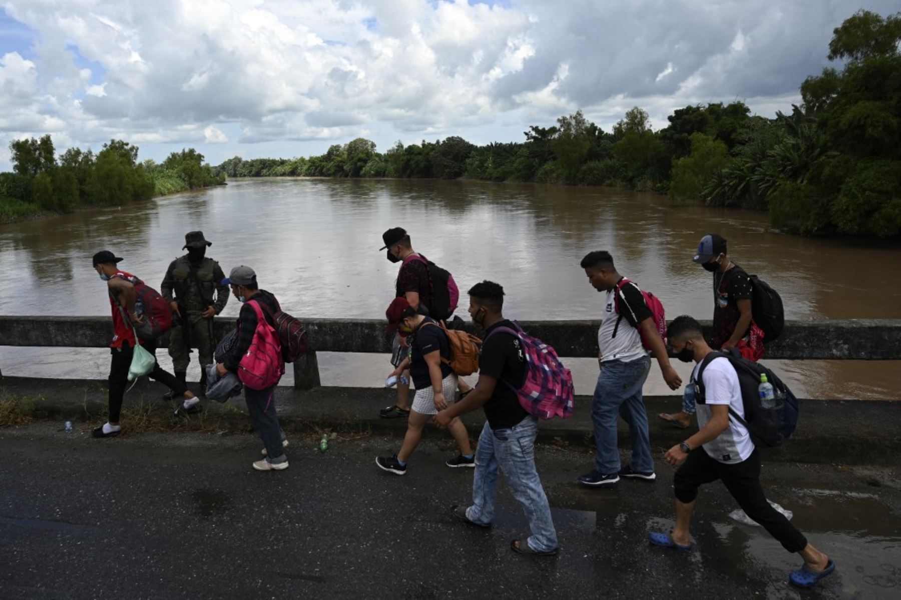 Los migrantes hondureños, parte de una caravana que se dirige a los Estados Unidos, cruzan un puente en Entre Ríos, Guatemala, luego de cruzar la frontera con Honduras. Foto: AFP