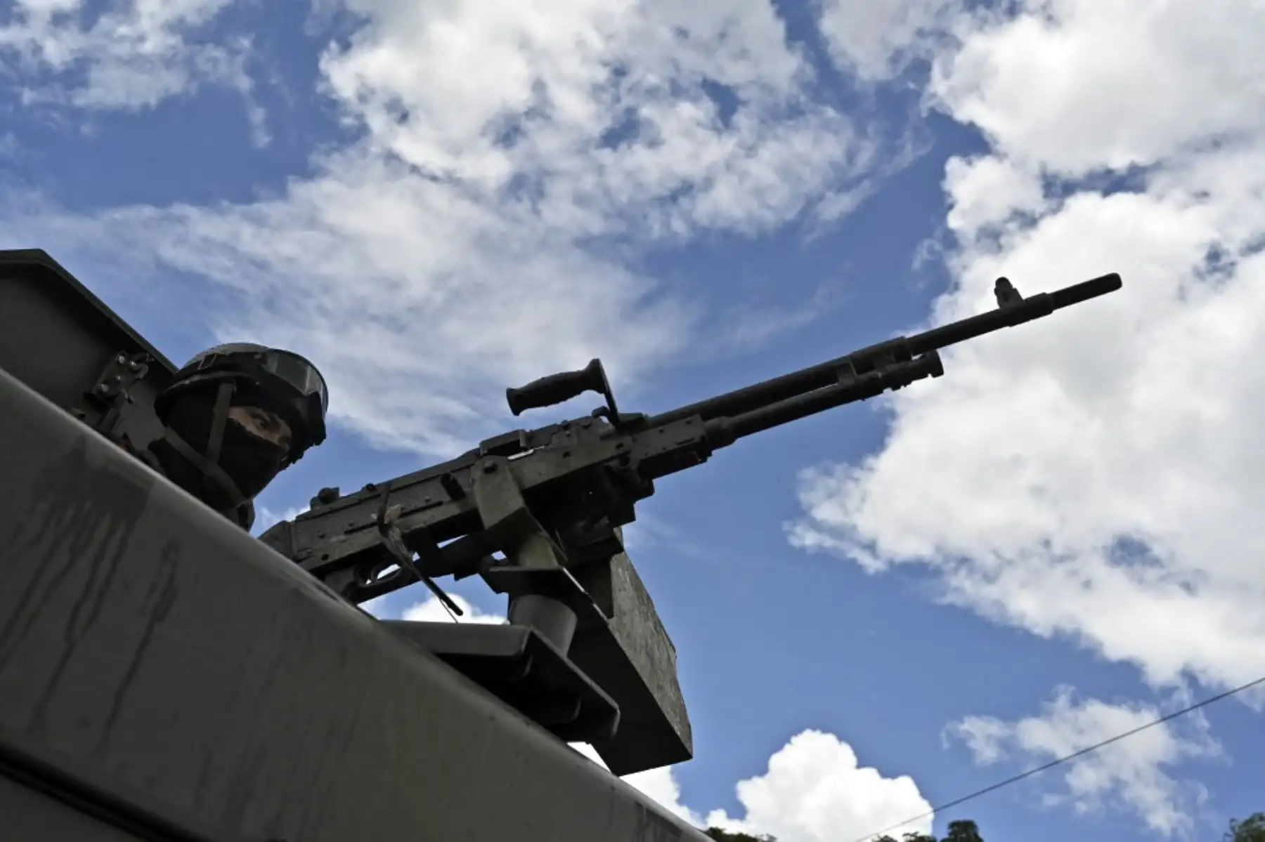Un miembro del Ejército de Guatemala hace guardia mientras los migrantes hondureños, parte de una caravana que se dirige a los Estados Unidos, caminan en Entre Ríos, Guatemala, después de cruzar la frontera con Honduras. Foto: AFP
