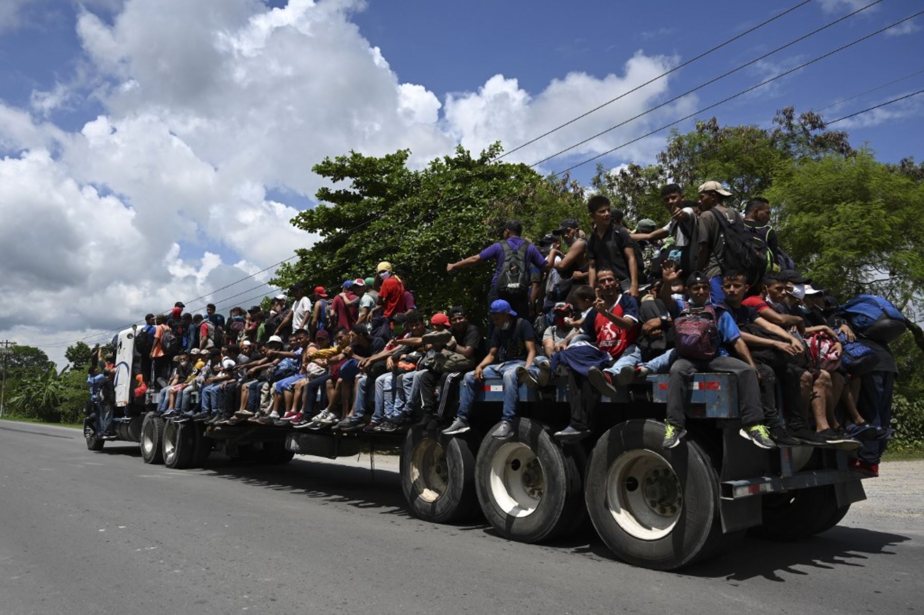 Migrantes hondureños, parte de una caravana rumbo a Estados Unidos, buscan agua que les entregan miembros del Ejército de Guatemala, en Entre Ríos, Guatemala, luego de cruzar la frontera de Honduras. Foto: AFP
