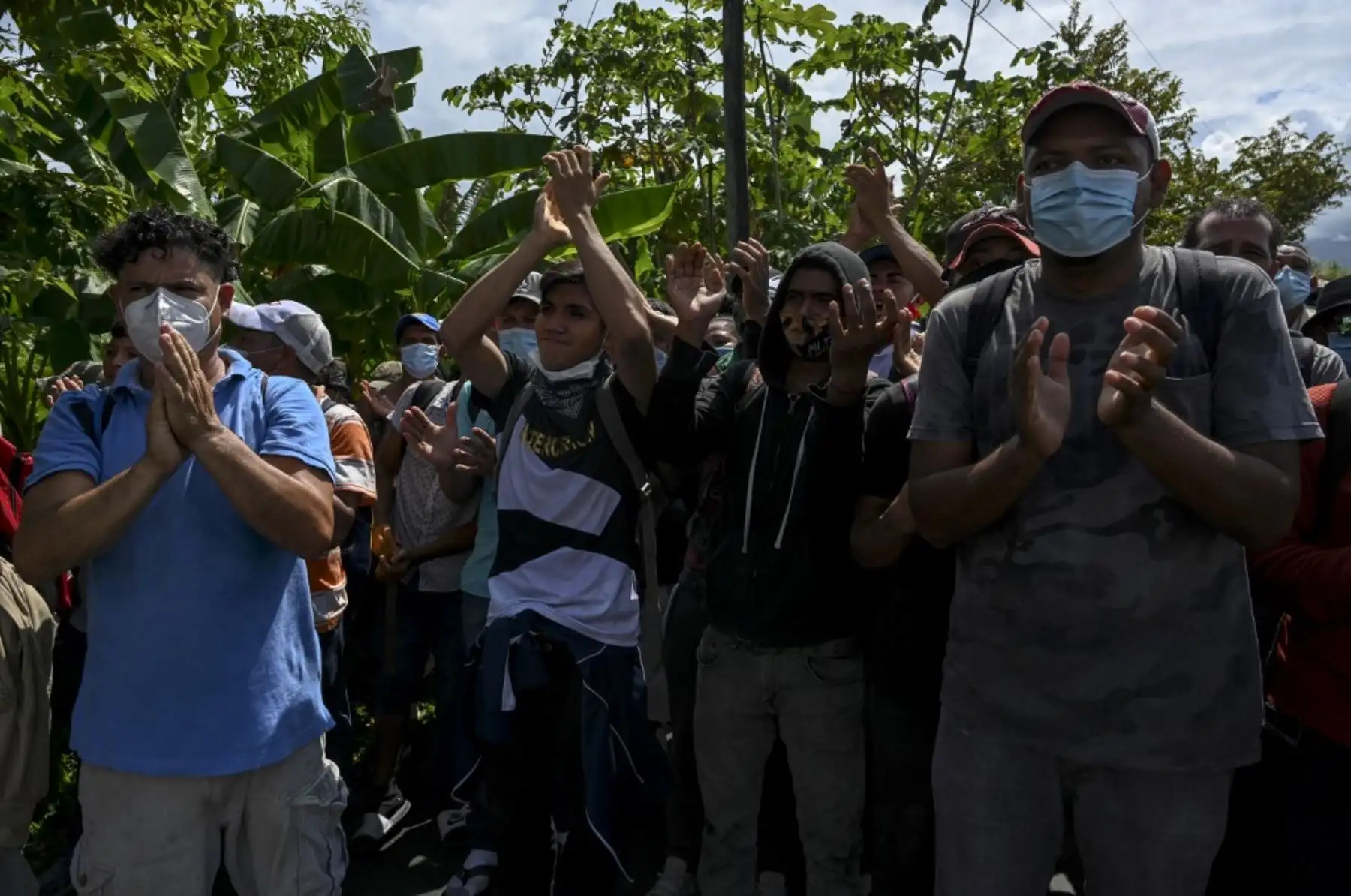 Los migrantes hondureños, parte de una caravana rumbo a Estados Unidos, aplauden a los miembros del Ejército de Guatemala que los dejaron pasar, en Entre Ríos, Guatemala, luego de cruzar la frontera de Honduras. Foto: AFP