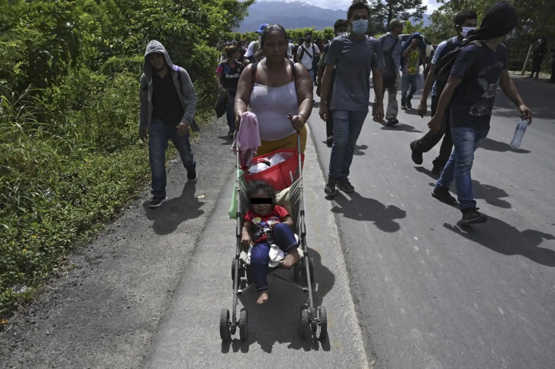 Un migrante hondureño, parte de una caravana que se dirige a Estados Unidos, empuja a un niño en un tranvía en Entre Ríos, Guatemala, luego de cruzar la frontera de Honduras. Foto: AFP