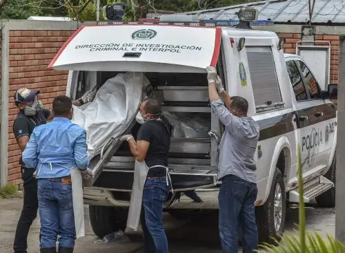 Policías descargan los cadáveres de víctimas de una masacre presuntamente a manos de grupos armados en el municipio colombiano de Arauca, en la morgue de Arauca, cerca de la frontera con Venezuela, el 22 de agosto de 2020. Foto: AFP