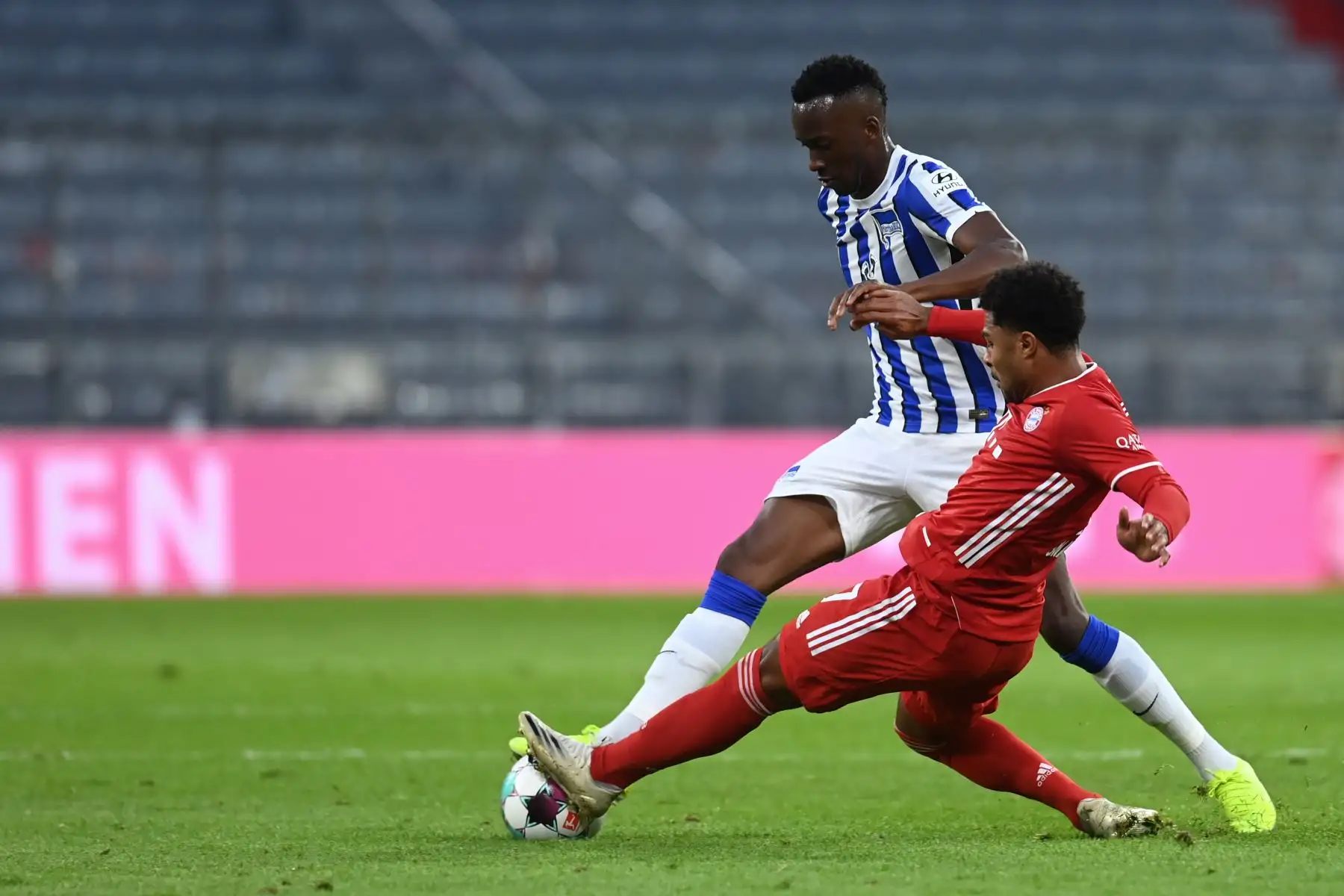 El mediocampista alemán del Bayern Munich, Serge Gnabry, y el delantero belga del Hertha Berlin, Dodi Lukebakio, se enfrentan durante por el balón durante el partido de fútbol de la Bundesliga. Foto: AFP