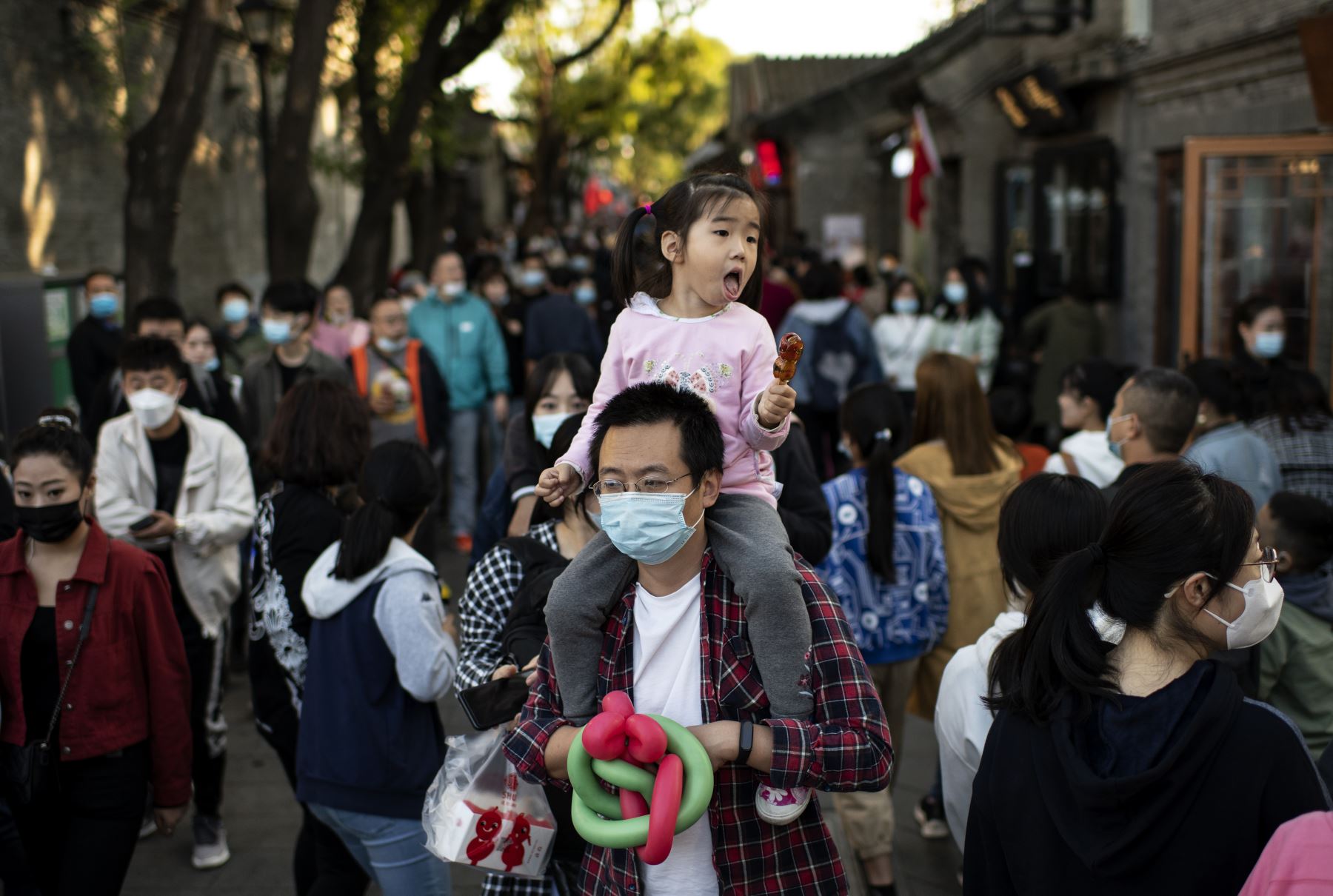 La gente pasa junto a las tiendas durante la festividad nacional de la "Semana Dorada" en Beijing. Foto: AFP