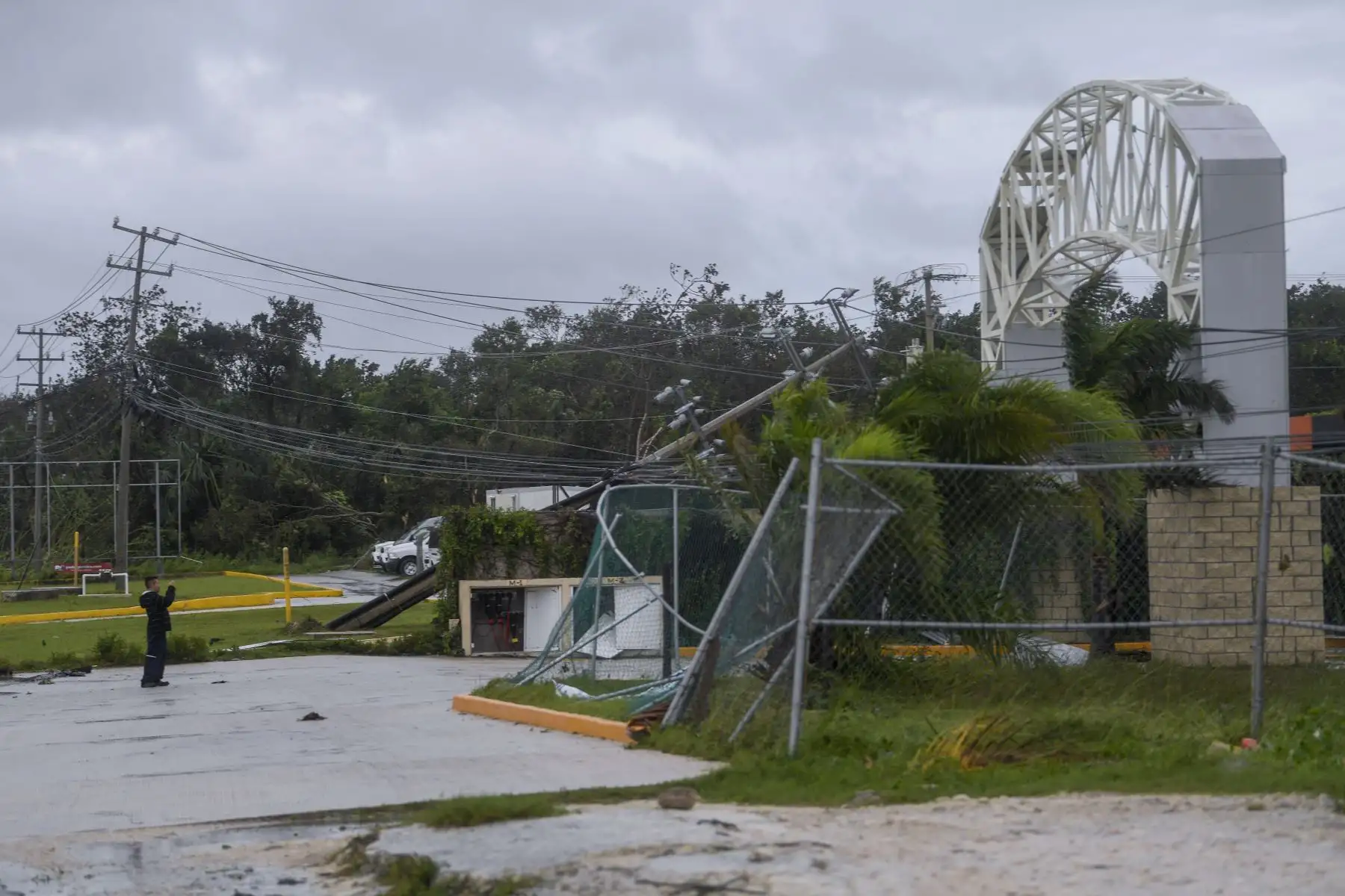 Un hombre toma fotografías de cables eléctricos y árboles caídos después del paso del huracán Delta en Cancún, estado de Quintana Roo, México. Foto: AFP
