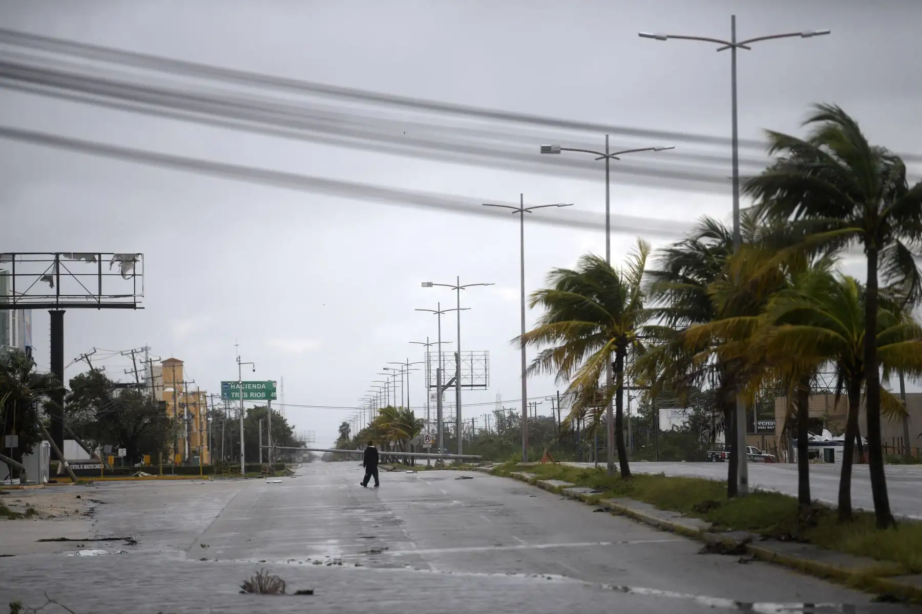 Un hombre camina a lo largo de una carretera dañada después del paso del huracán Delta en Cancún, estado de Quintana Roo, México. Foto: AFP