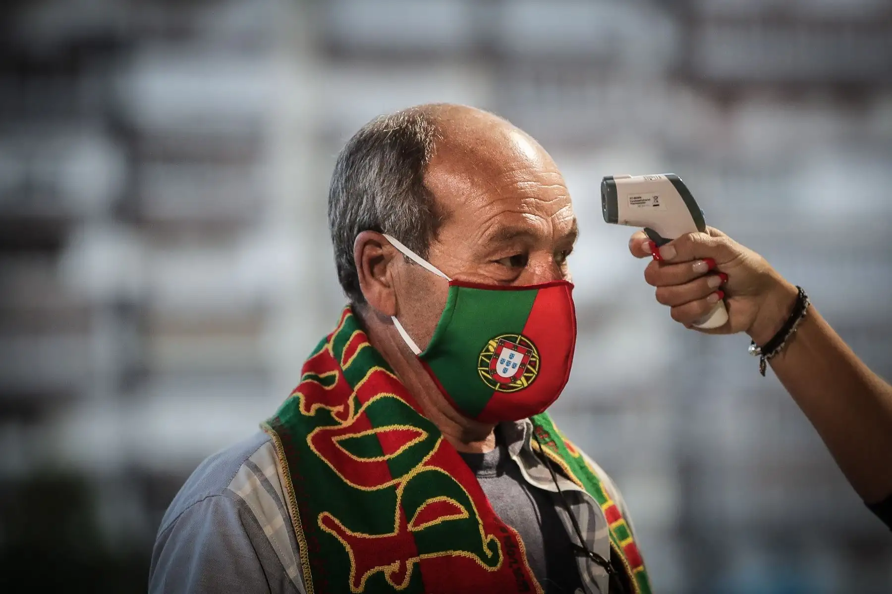 Un hombre con máscara protectora pasa los protocolos de control antes del partido amistoso de fútbol entre Portugal y España en el estadio Alvalade, en Lisboa. Foto: AFP