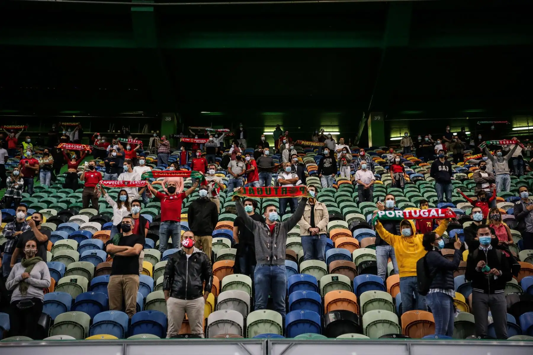 Hinchas con máscaras protectoras y manteniendo la distancia social durante el partido amistoso entre Portugal y España en el estadio Alvalade, en Lisboa. Foto: AFP