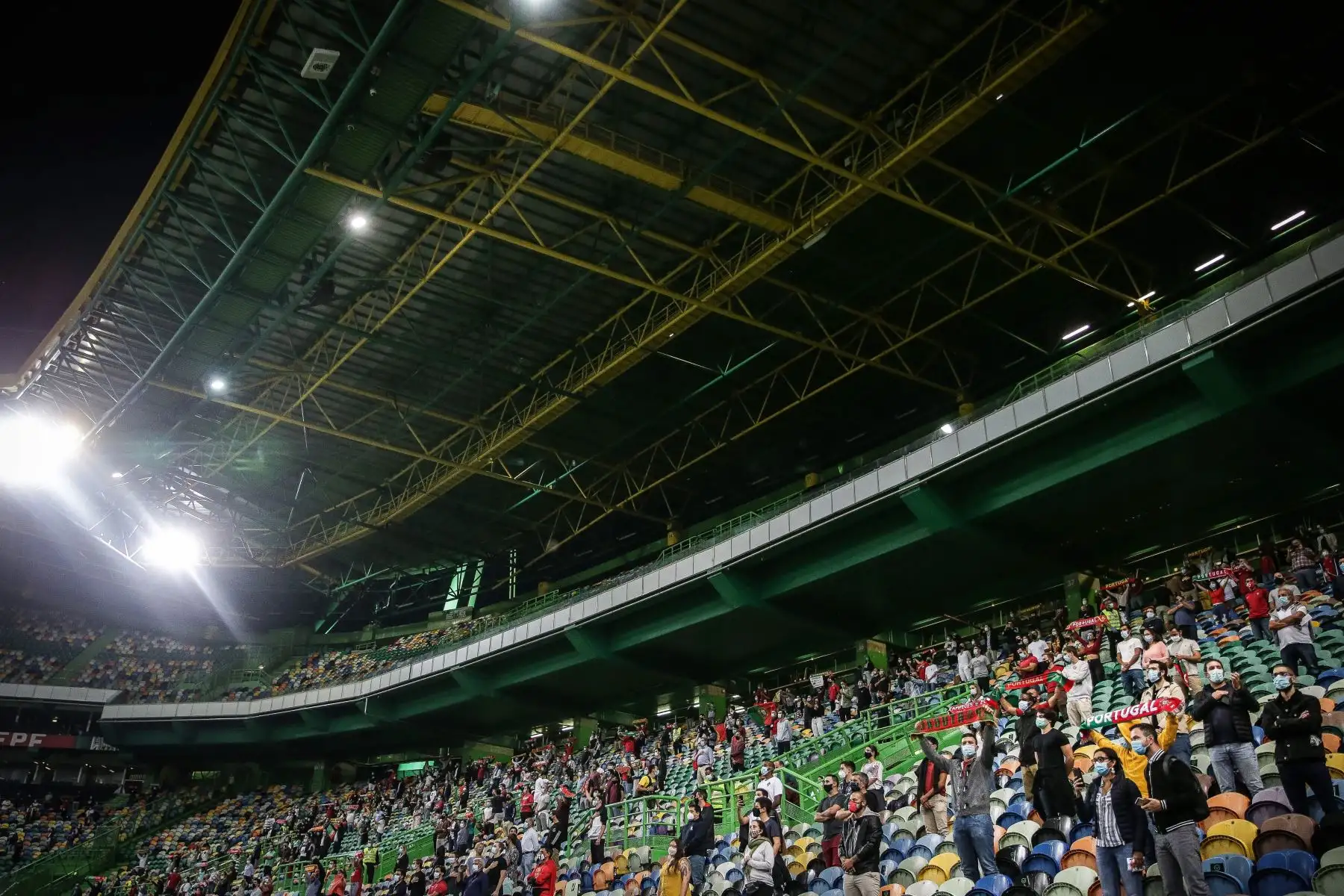 Hinchas con máscaras protectoras y manteniendo la distancia social durante el partido amistoso entre Portugal y España en el estadio Alvalade, en Lisboa. Foto: AFP