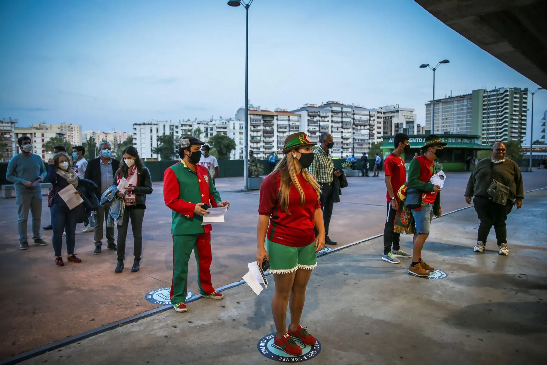 Los aficionados llevan máscaras protectoras y mantienen la distancia social durante su ingreso al estadio Alvalade, en Lisboa. Foto: AFP
