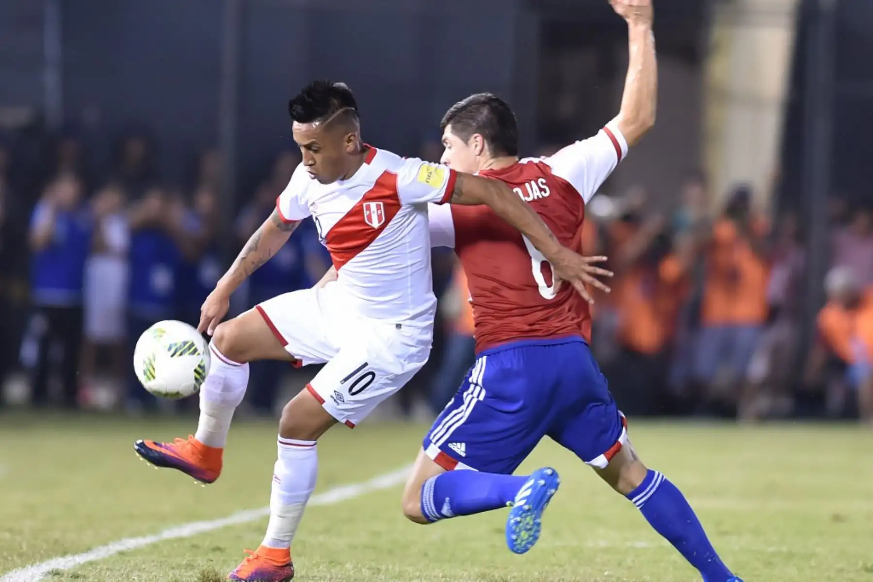 El delantero peruano Christian Cueva y el paraguayo Rodrigo Rojas compiten por el balón. Foto: AFP