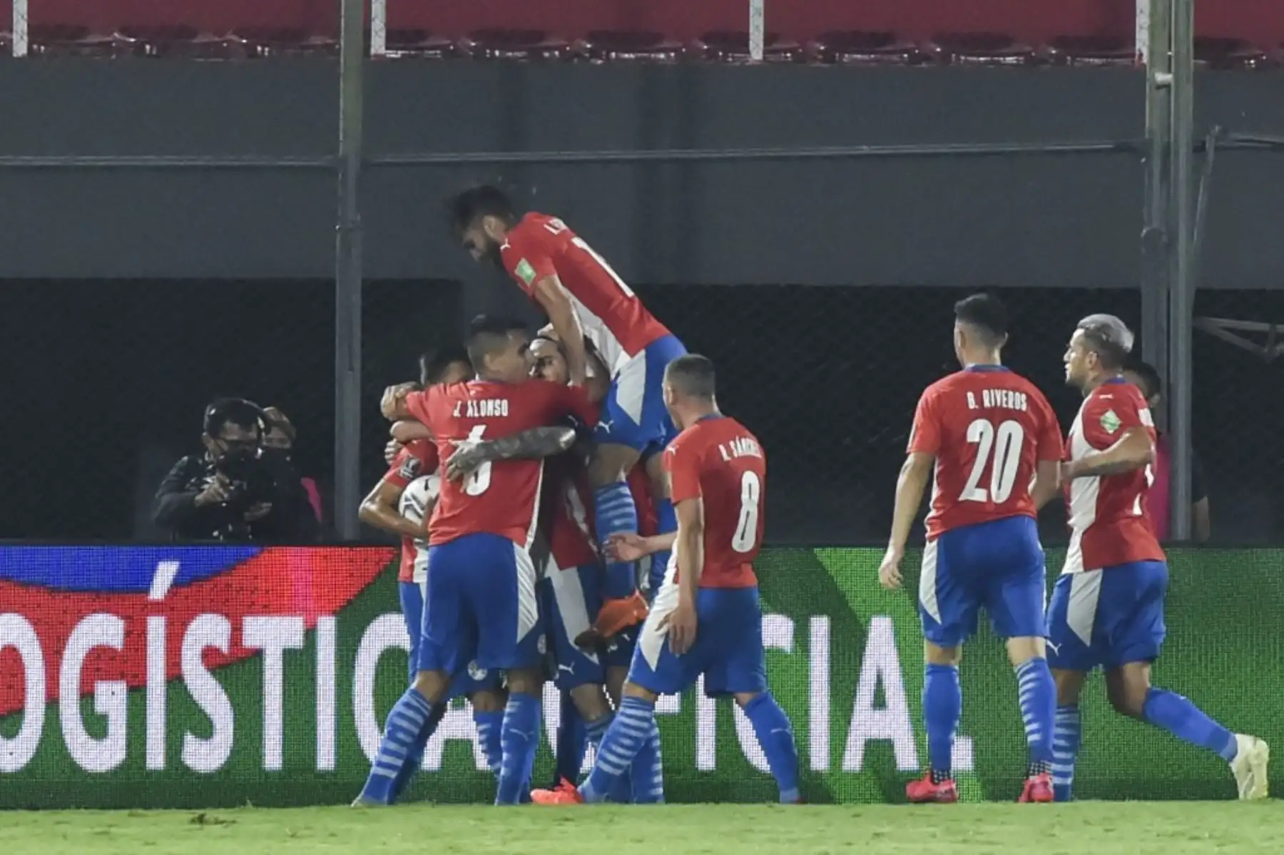 Ángel Romero de Paraguay (cubierto) celebra con sus compañeros de equipo después de anotar contra Perú durante su partido de fútbol clasificatorio sudamericano para la Copa Mundial de la FIFA 2022 en el Estadio Defensores del Chaco en Asunción el 8 de octubre de 2020, en medio de la pandemia del nuevo coronavirus COVID-19. Foto: AFP