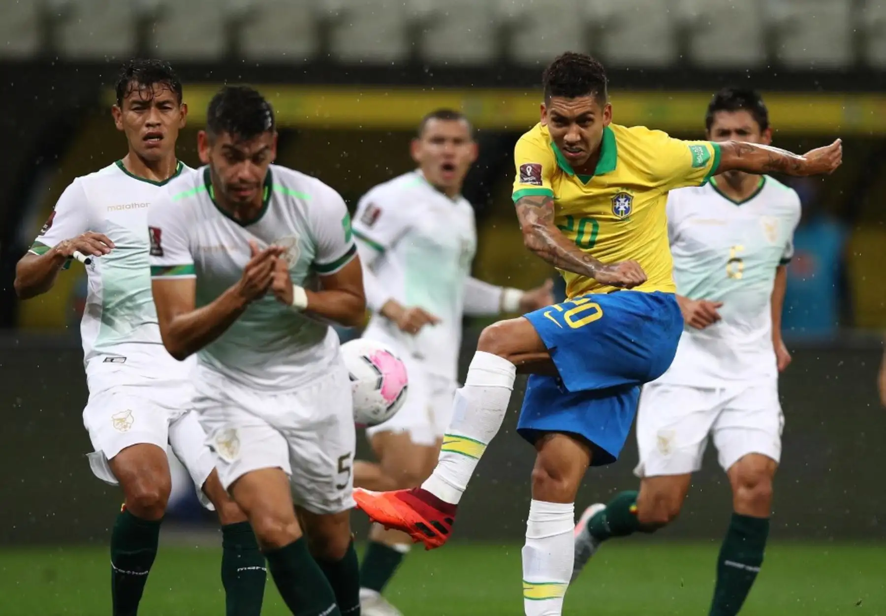 El brasileño Roberto Firmino (derecha) y el boliviano José María Carrasco compiten por el balón durante su partido de fútbol clasificatorio sudamericano para la Copa Mundial de la FIFA 2022 en el Neo Química Arena, también conocido como Itaquerao, en Sao Paulo, Brasil. Foto: AFP