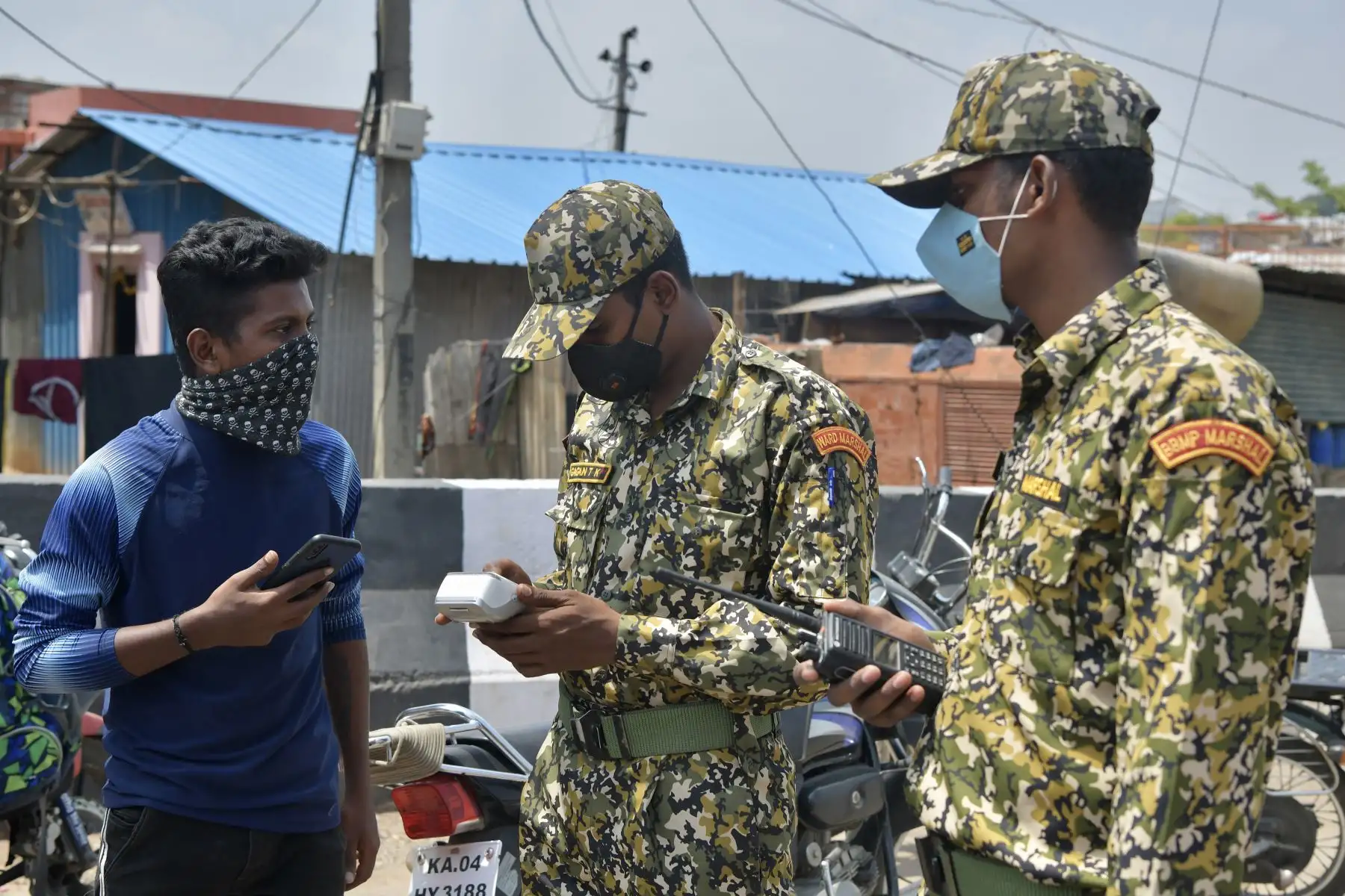 Los alguaciles municipales de Bruhath Bengaluru Mahanagara Palike multan a un hombre por no usar adecuadamente la mascarilla en medio de la pandemia del coronavirus, en Bangalore. Foto: AFP