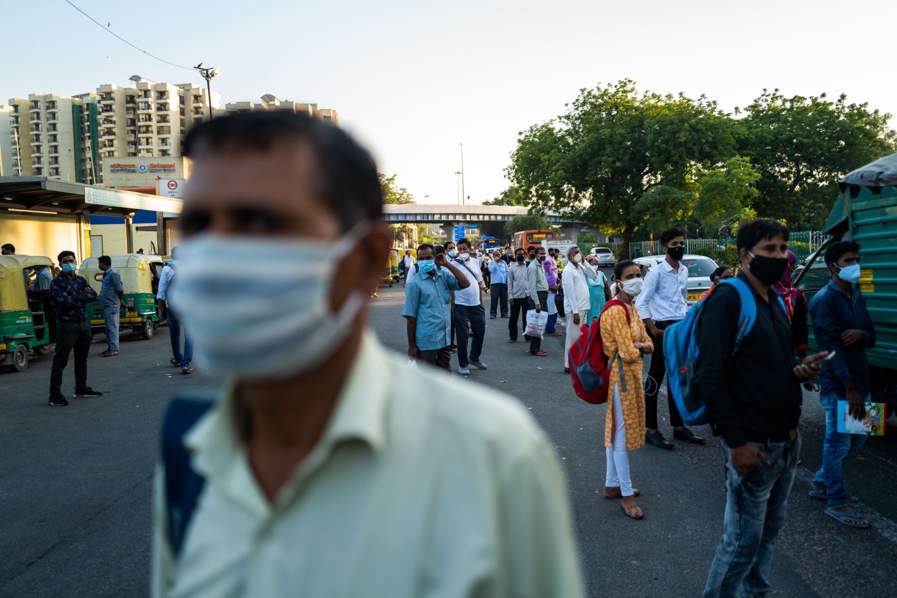 Los usuarios del transporte usan mascarillas como medida preventiva contra el coronavirus mientras esperan un autobús en una calle de Nueva Delhi. Foto: AFP