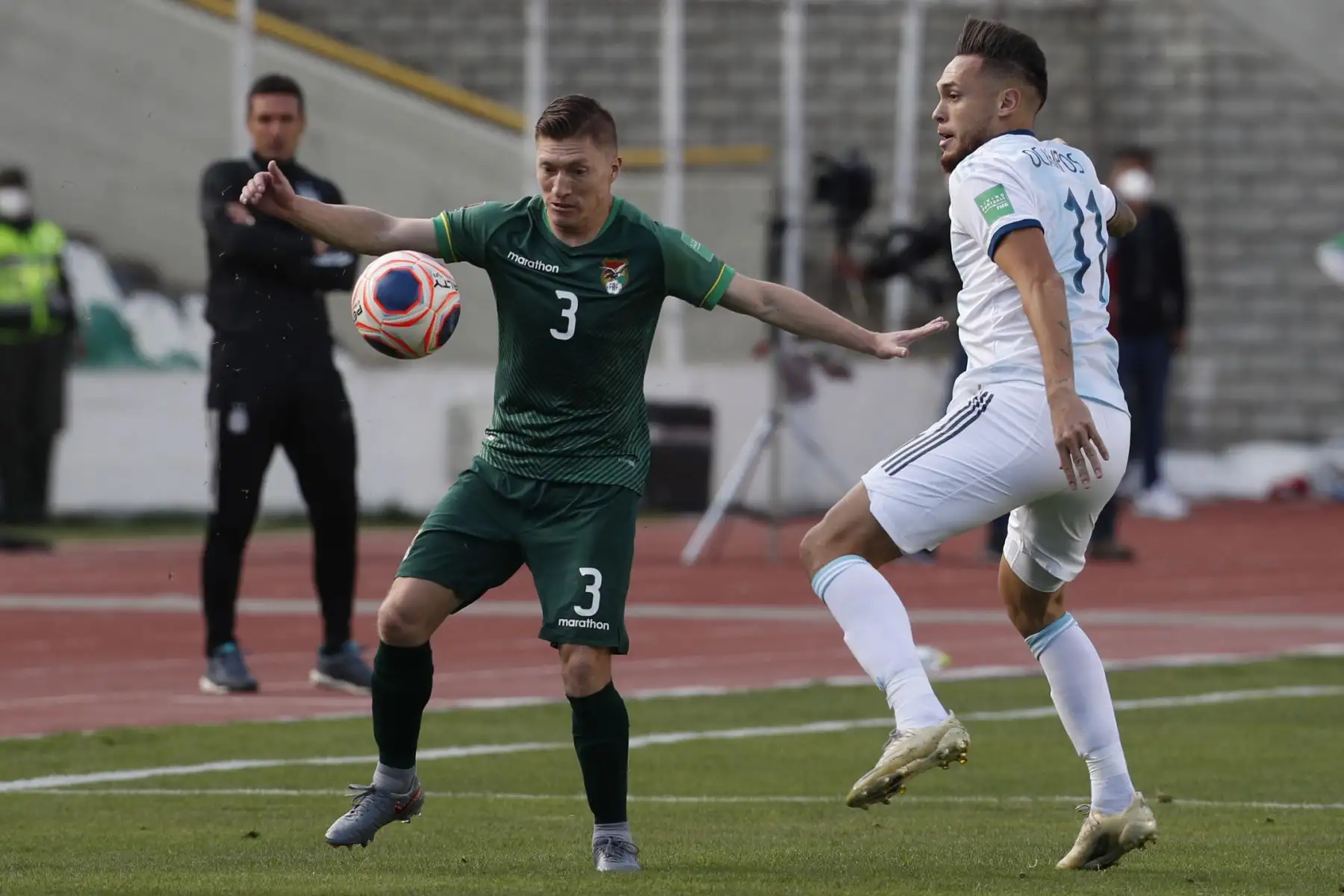 El boliviano Alejandro Chumacero disputa el balón frente al argentino Lucas Ocampos durante su partido de fútbol por Clasificatorias Qatar 2022, en el Estadio Hernando Siles en La Paz. Foto: AFP