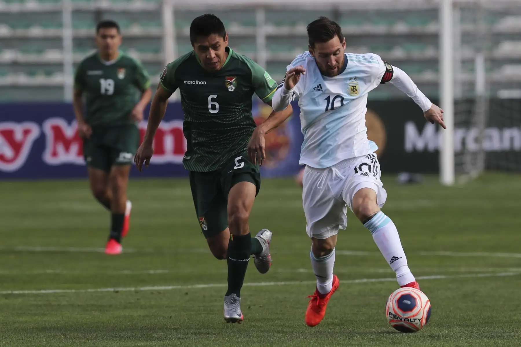 El argentino Lionel Messi es desafiado por el boliviano Diego Wayar durante partido por Clasificatorias Qatar 2022, en el estadio Hernando Siles en La Paz. Foto: AFP