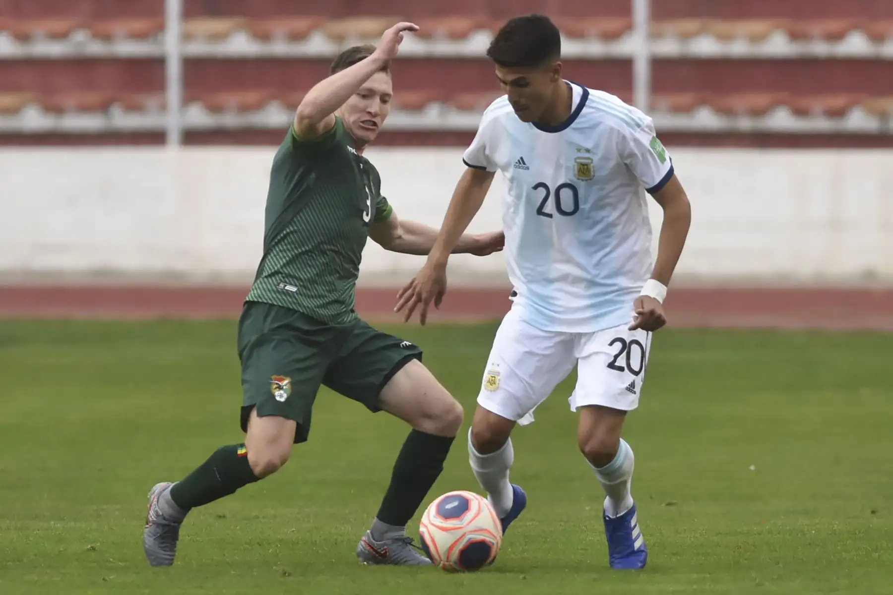 El boliviano Alejandro Chumacero se enfrenta a Exequiel Palacios durante partido por Clasificatorias Qatar 2022, en el Estadio Hernando Siles, en La Paz. Foto: AFP