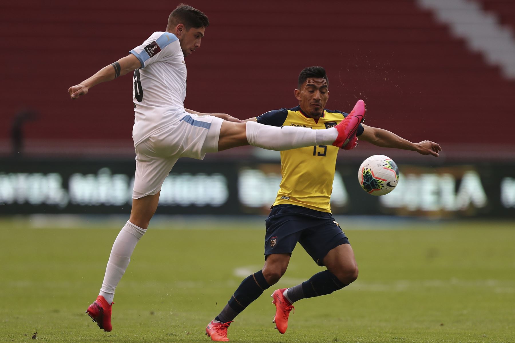 El ecuatoriano Angel Mena y el uruguayo Federico Valverde compiten por el balón durante partido por Clasificatorias Qatar 2022, en el Estadio Rodrigo Paz Delgado, en Quito. Foto: AFP