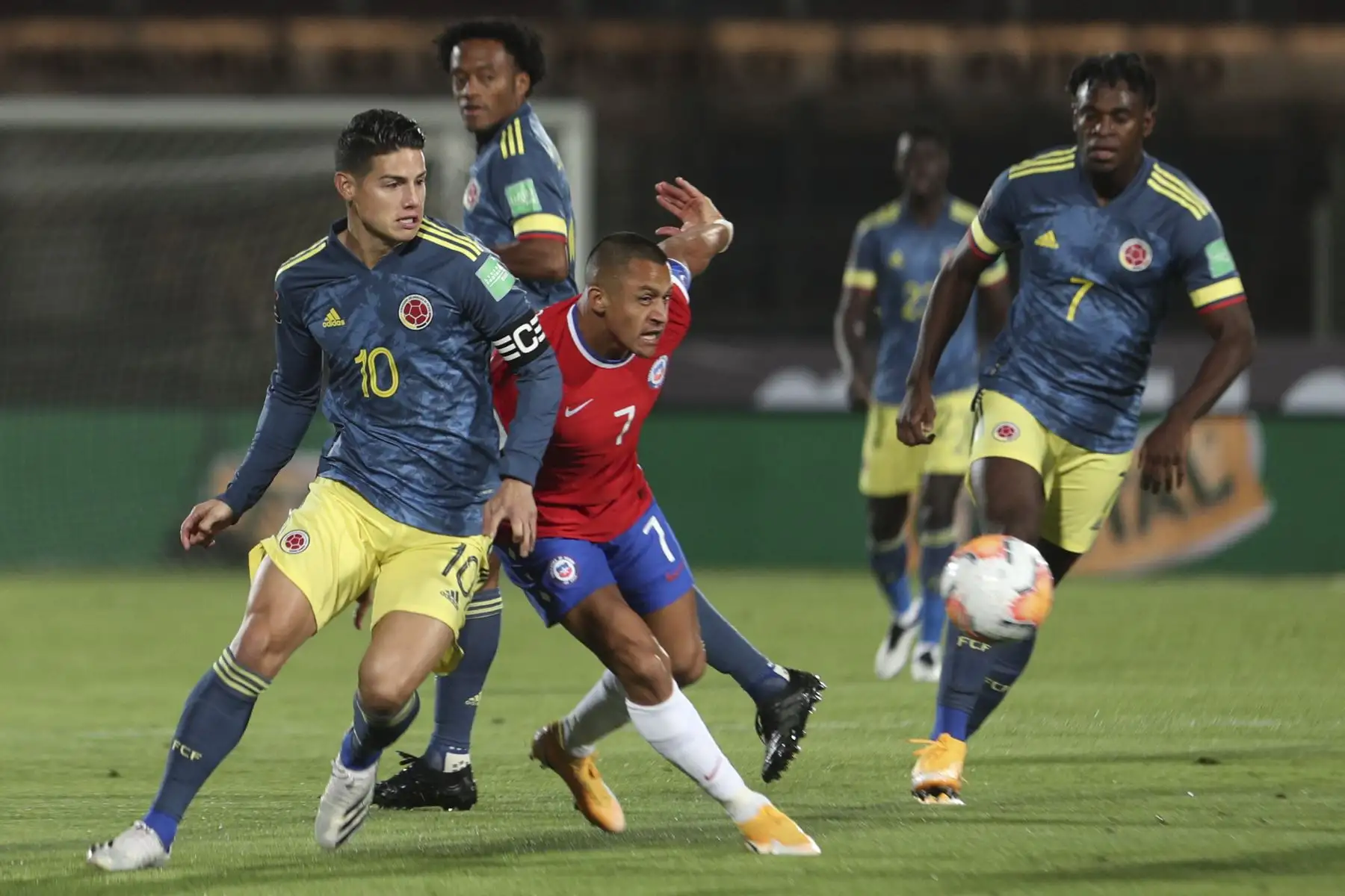 El colombiano James Rodríguez y el chileno Alexis Sánchez compiten por el balón durante partido por Clasificatorias Qatar 2022, en el Estadio Nacional de Santiago. Foto: AFP