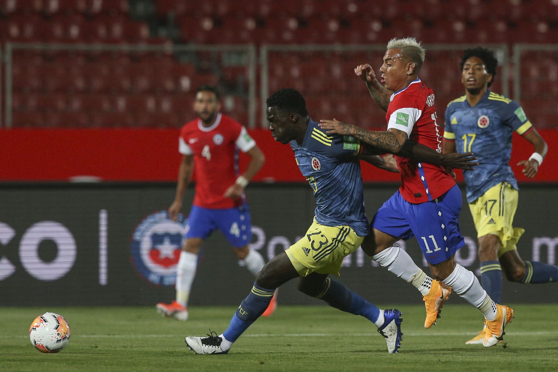 El chileno Eduardo Vargas y el colombiano Davinson Sánchez compiten por el balón durante partido por Clasificatorias Qatar 2022, en el Estadio Nacional de Santiago. Foto: AFP