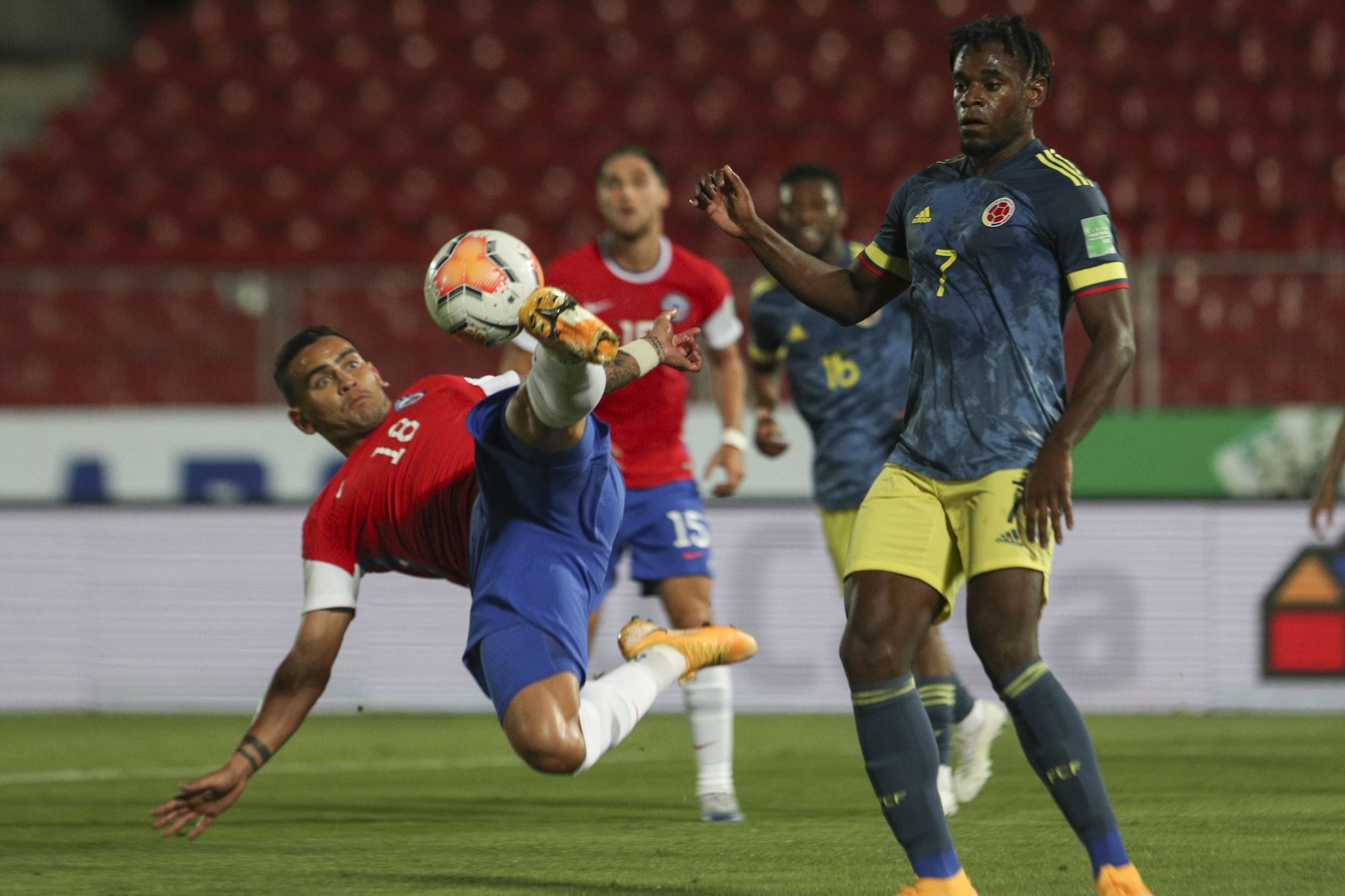 El colombiano Duvan Zapata y el chileno Sebastian Vegas compiten por el balón durante partido por Clasificatorias Qatar 2022, el Estadio Nacional de Santiago. Foto: AFP