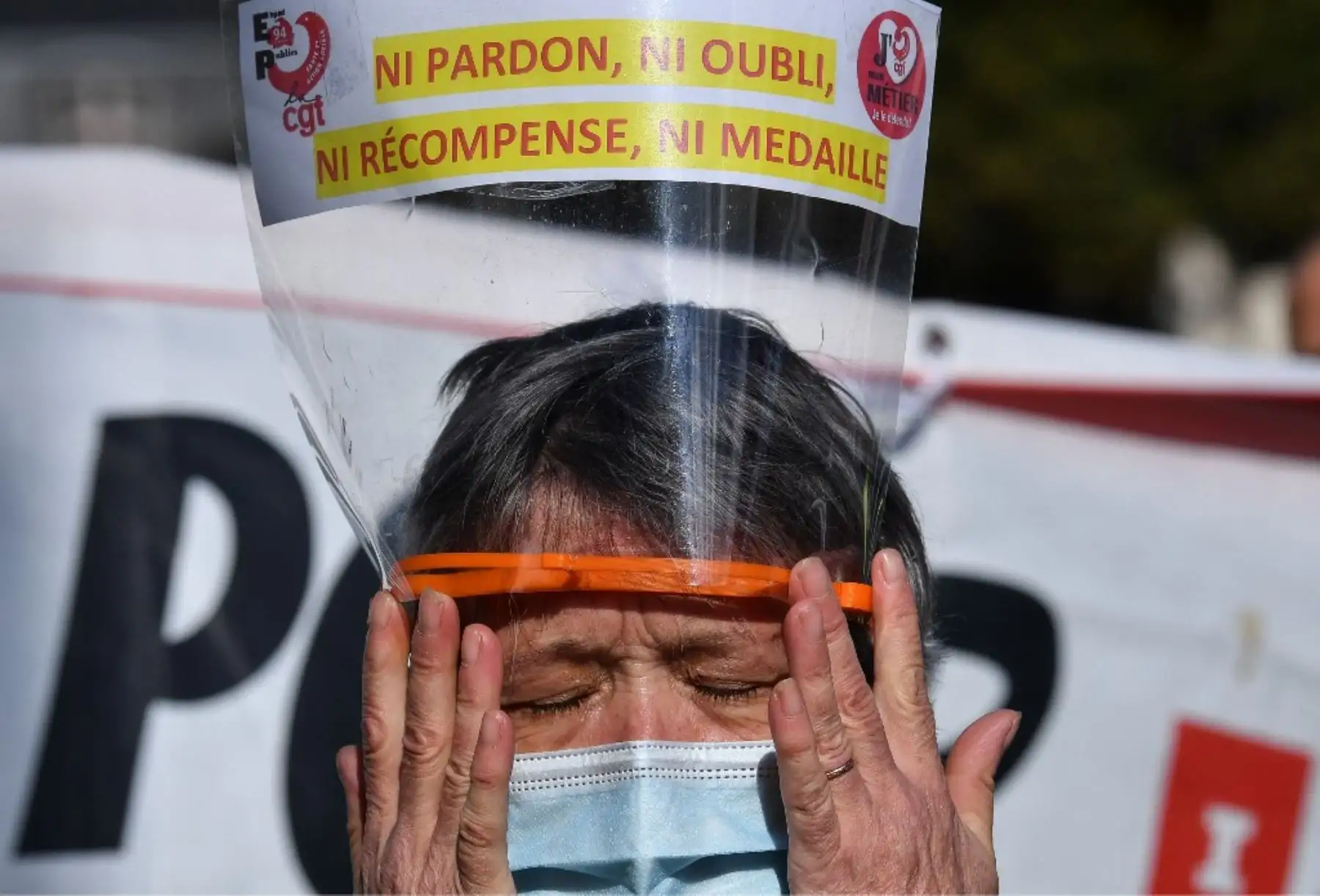 Una enfermera usa una mascarilla protectora y una visera que dice, 