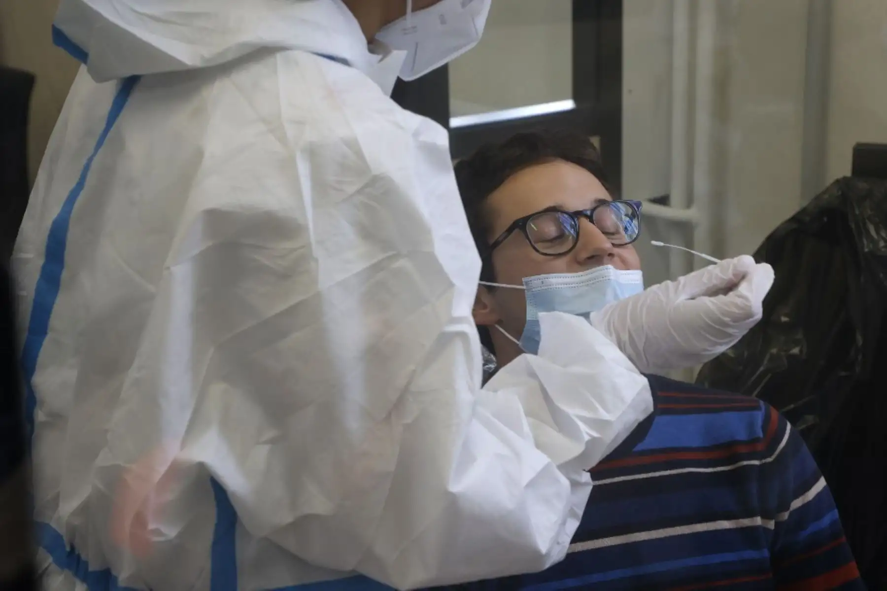Un personal médico realiza una prueba a un estudiante en un centro de pruebas Covid-19 ubicado en el antiguo Ayuntamiento del distrito 4. Foto: AFP