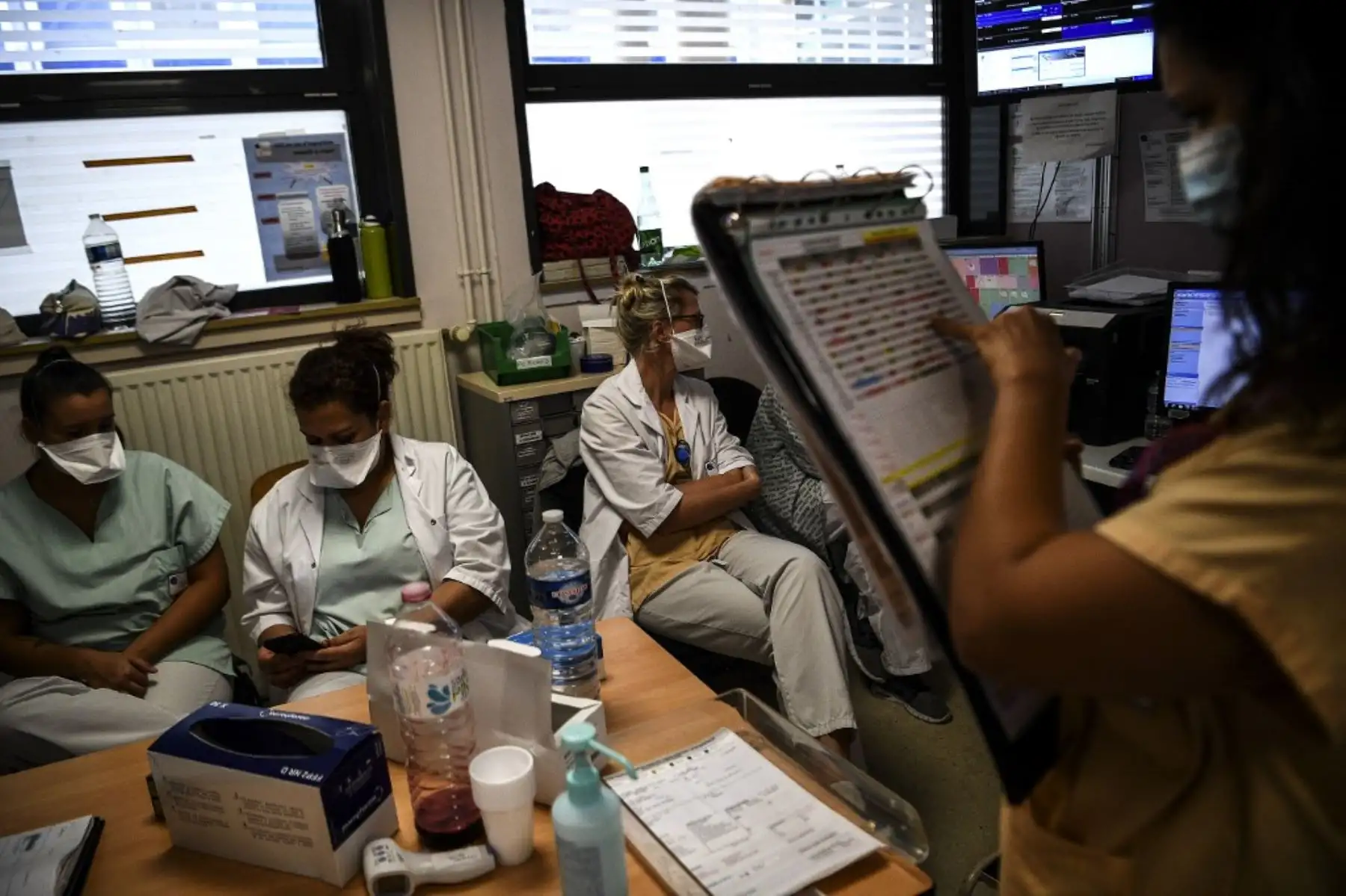 Los trabajadores médicos verifican la información en sus teléfonos y un gráfico en el servicio de emergencia del hospital Andre Gregoire en Montreuil, al este de París. Foto: AFP