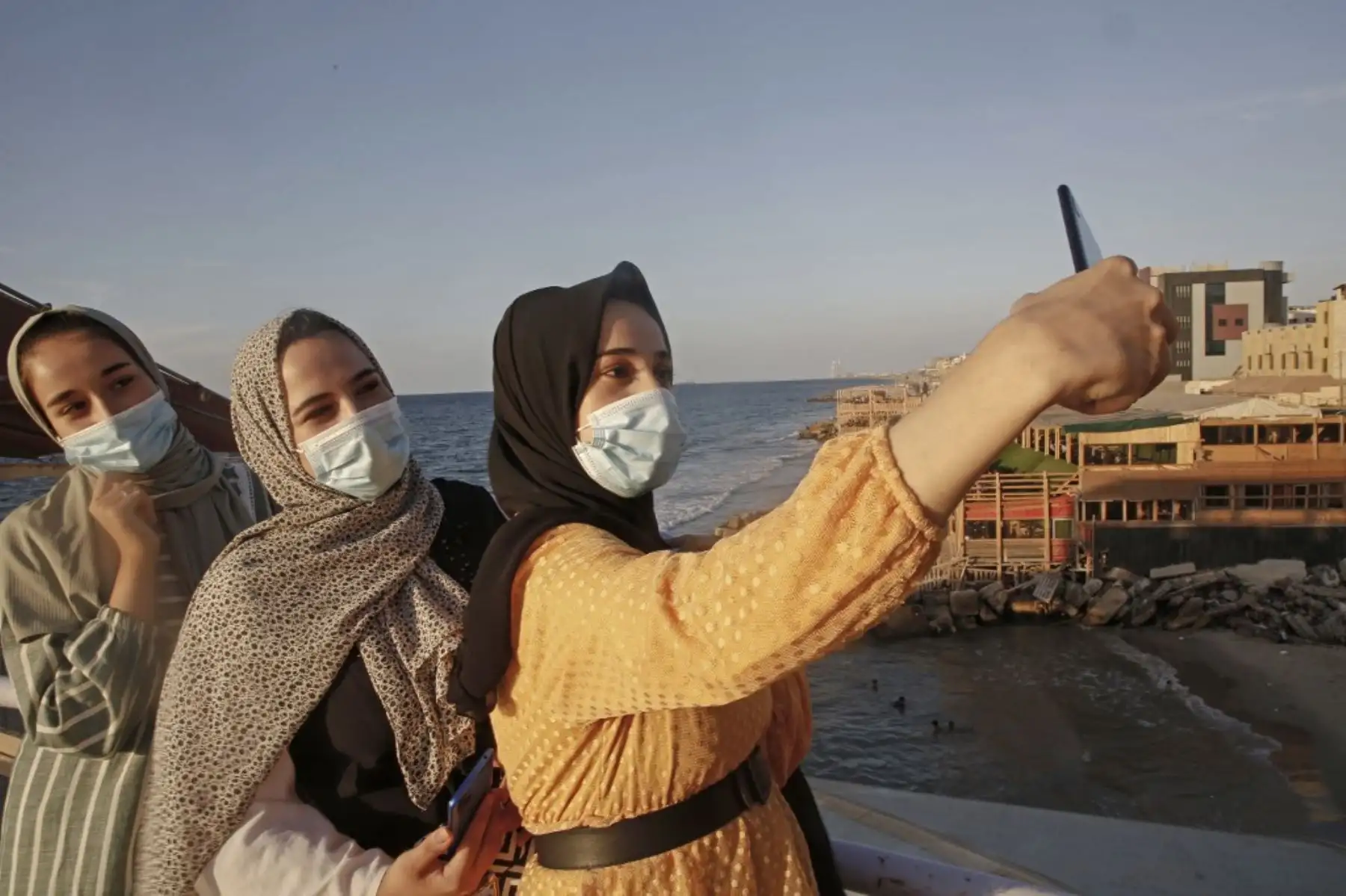 Mujeres palestinas se toman una selfie al atardecer en la ciudad de Gaza en medio de estrictas restricciones debido a la pandemia de COVID-19 el 12 de octubre de 2020. Foto: AFP
