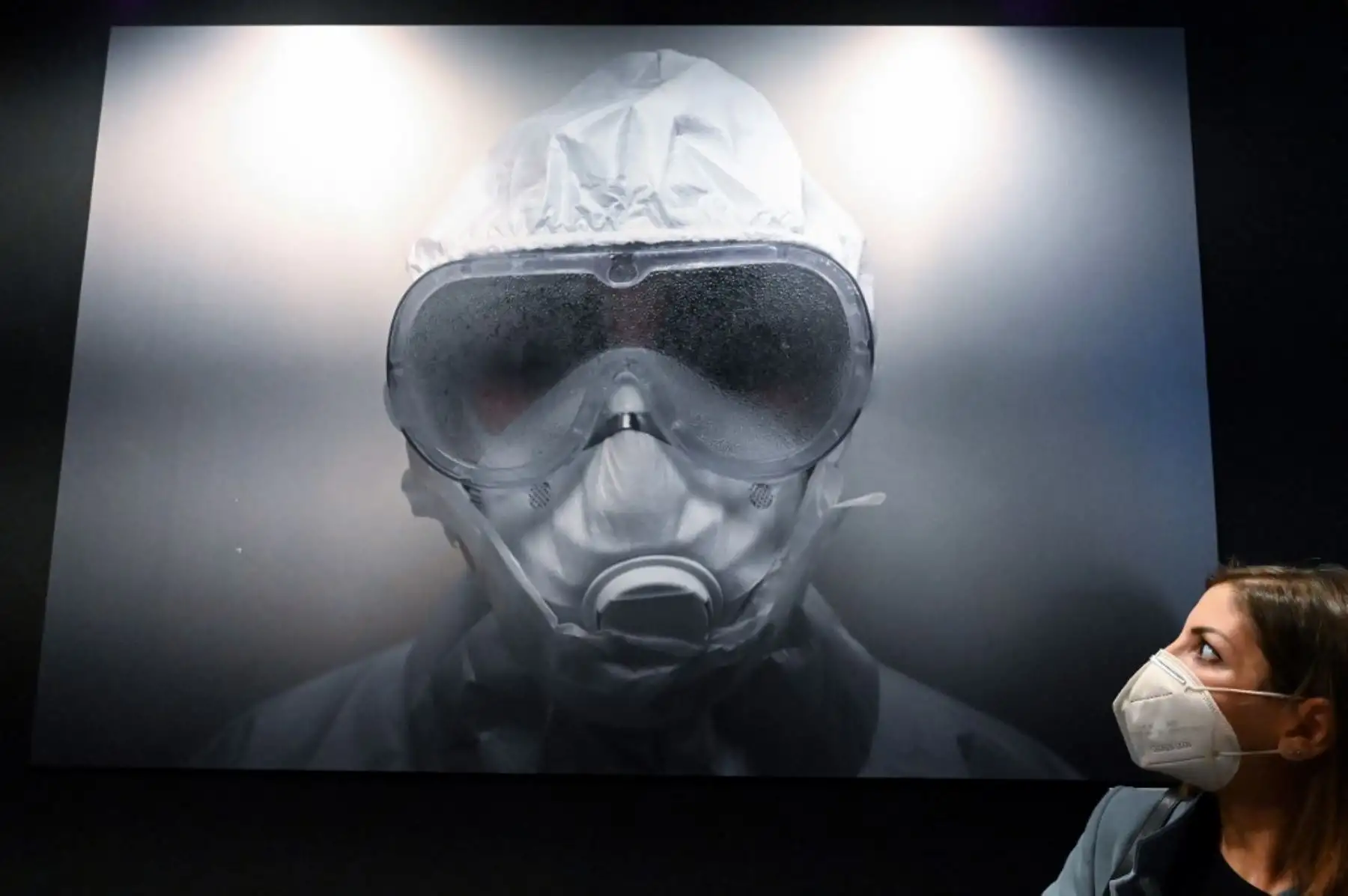 La enfermera Emanuela Buzzurro "Manu" posa junto a su retrato gigante durante la exposición "Lockdown Italia by Foreign Press" en Roma. Foto: AFP