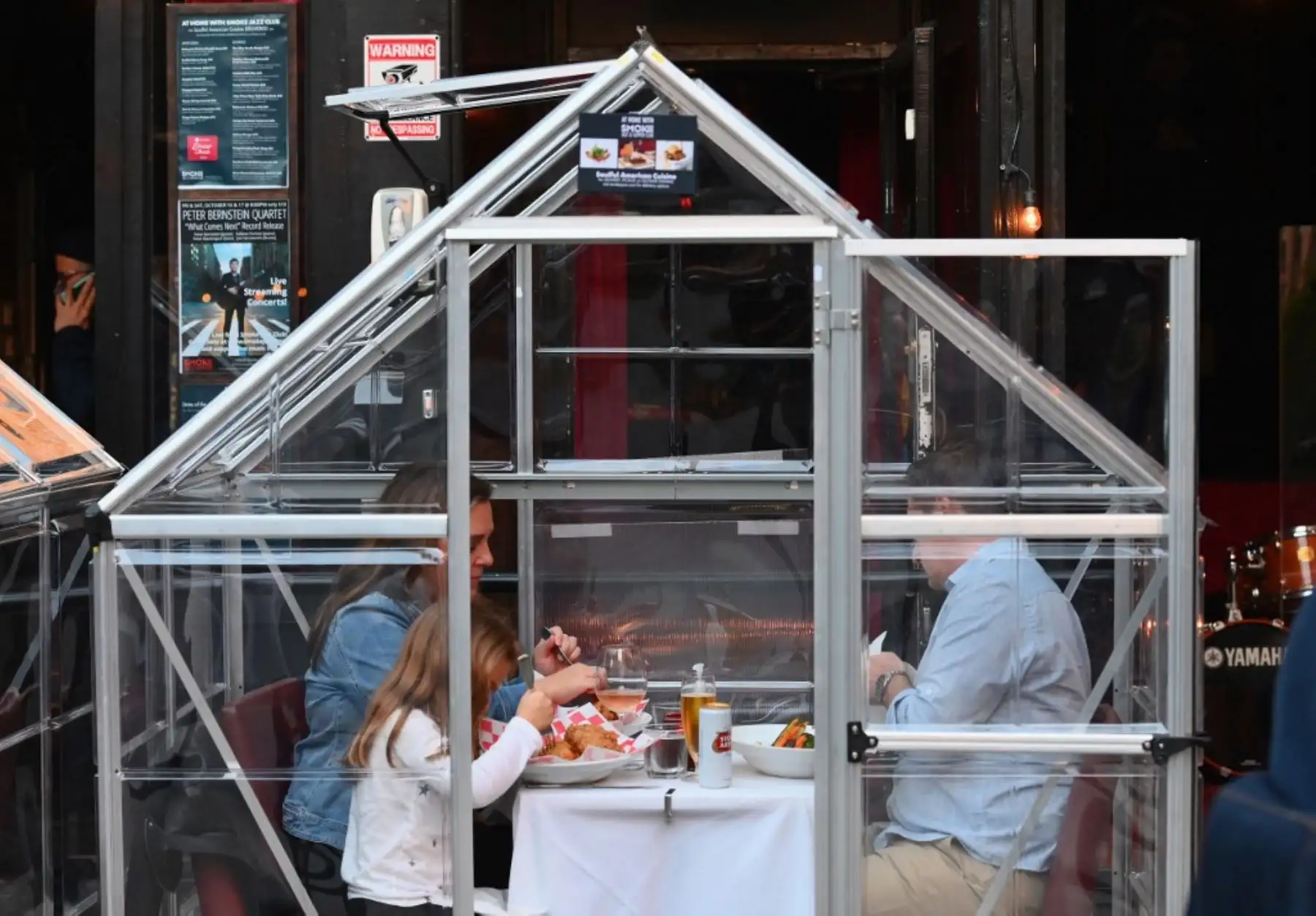 La gente cena en carpas de plástico por distanciamiento social en un restaurante en Manhattan en la ciudad de Nueva York, en medio de la pandemia de coronavirus. Foto: AFP