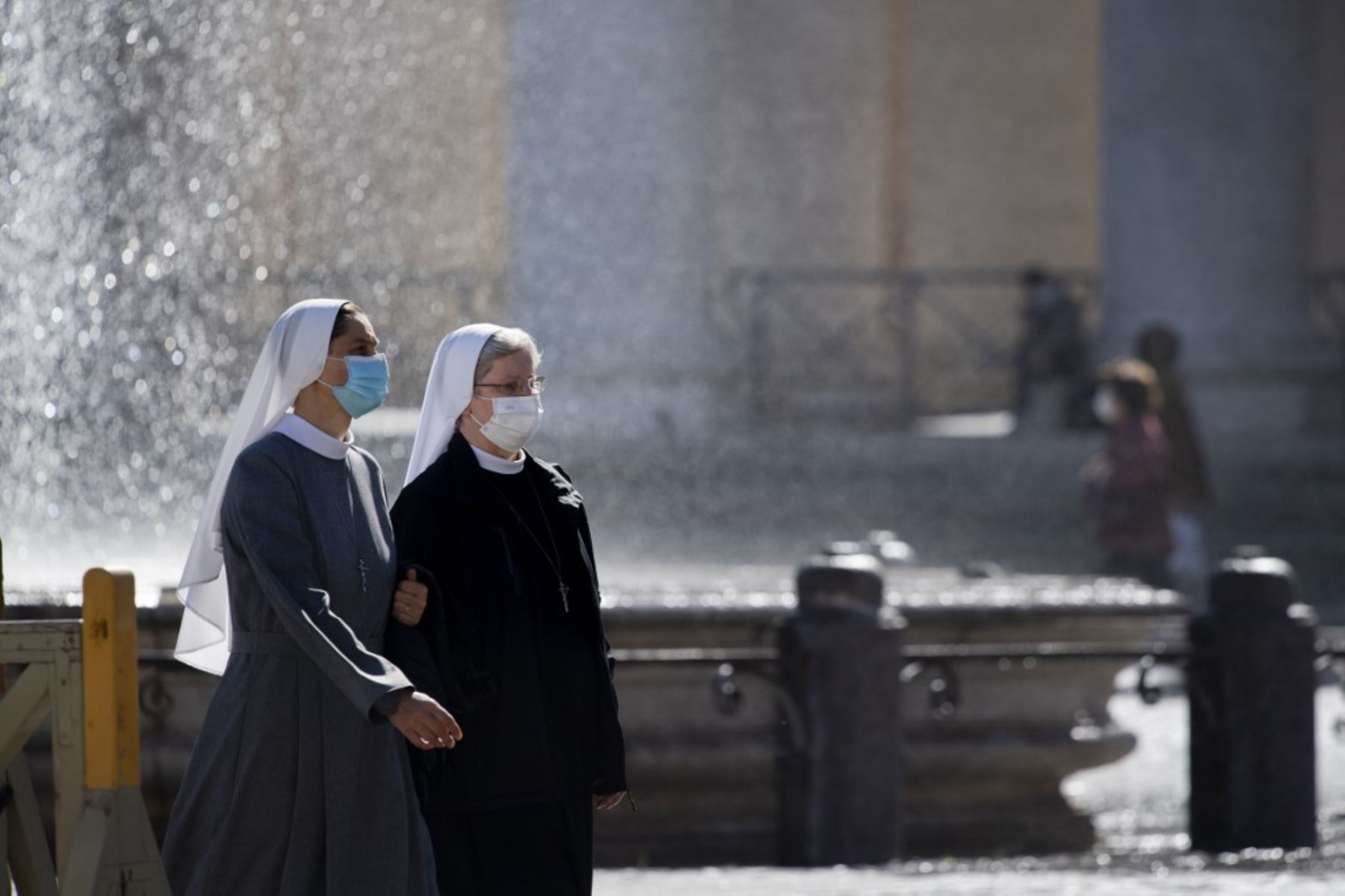 Monjas con máscaras protectoras caminan en la Plaza de San Pedro en el Vaticano. Foto: AFP
